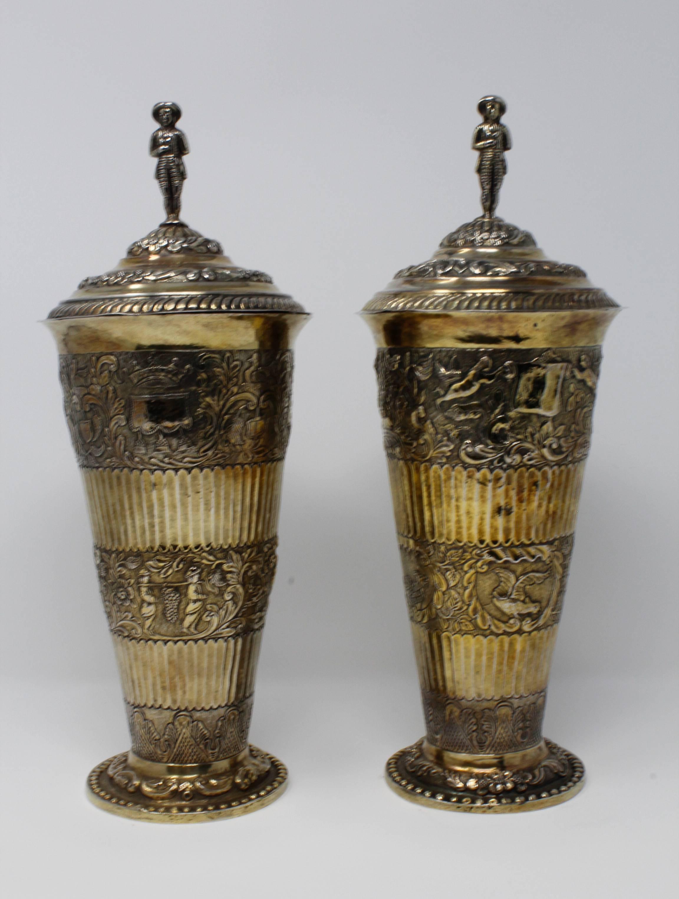 Covered Vases w/ Removable Lids, Gilt Silver, German c.1870, in 17th cent. style. Each vase depicts a different design.  Both vases weigh a total of 67 Troy oz.