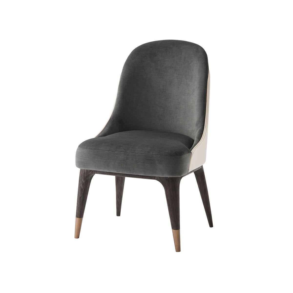 With a leather wrapped and tailored back, upholstered back and seat, on solid oak legs in a 'cigar club' finish. Legs capped with bronze finish metal foot.
Dimensions: 21.25