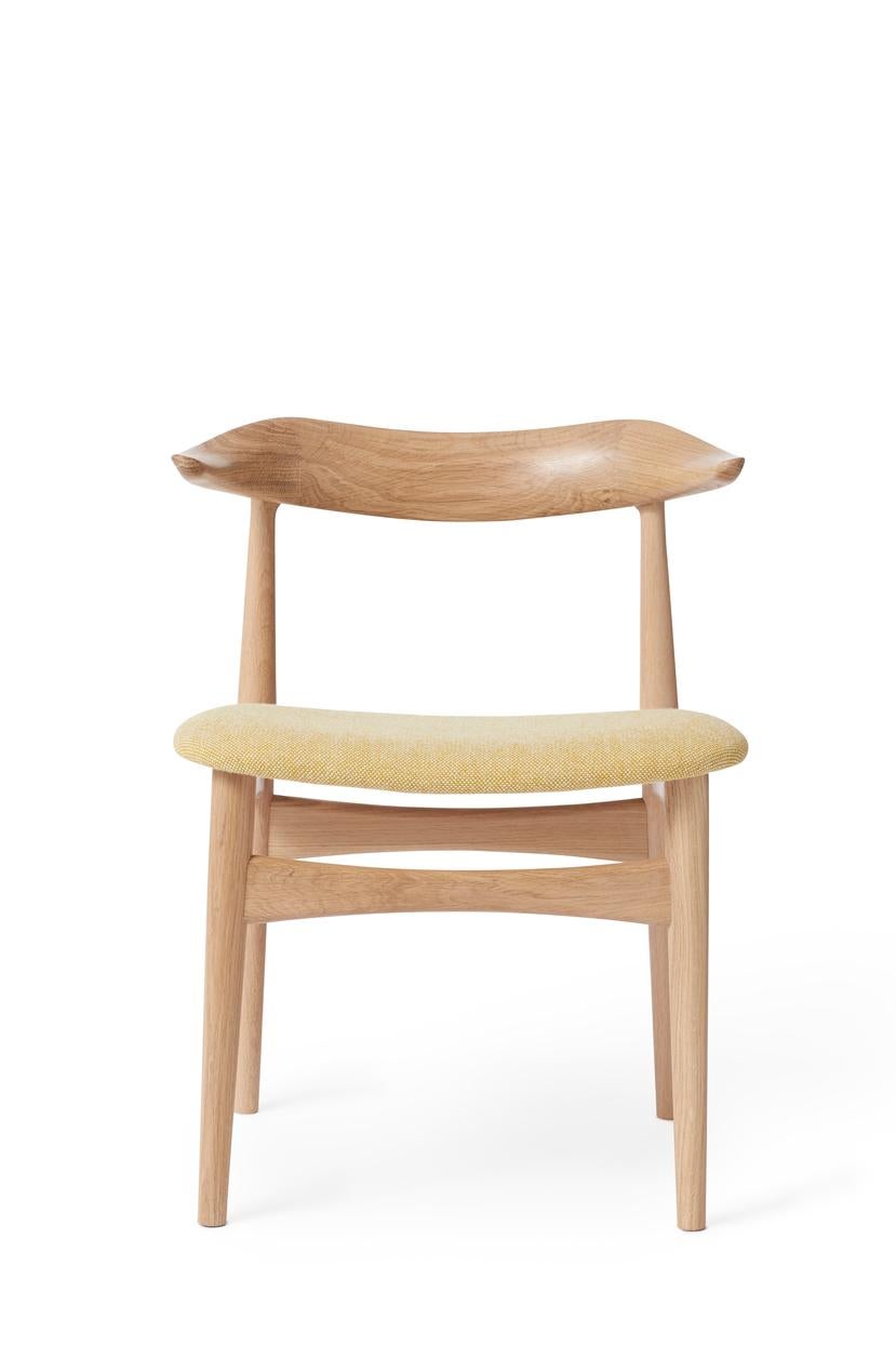 Cow Horn chair oak vanilla by Warm Nordic
Dimensions: D 55 x W 48 x H 74 cm
Material: White oiled solid oak frame, Textile or leather upholstery.
Weight: 7.5 kg
Also available in different colours and finishes.

The Cow Horn Chair is an iconic