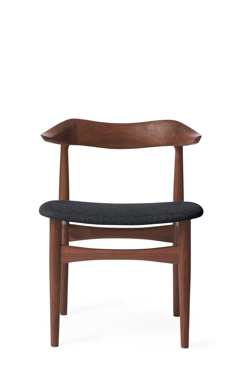 Cow Horn chair walnut anthracite melange by Warm Nordic
Dimensions: D 55 x W 48 x H 74 cm
Material: Oiled solid walnut frame, Textile or leather upholstery.
Weight: 7.5 kg
Also available in different colours and finishes.

The Cow Horn Chair