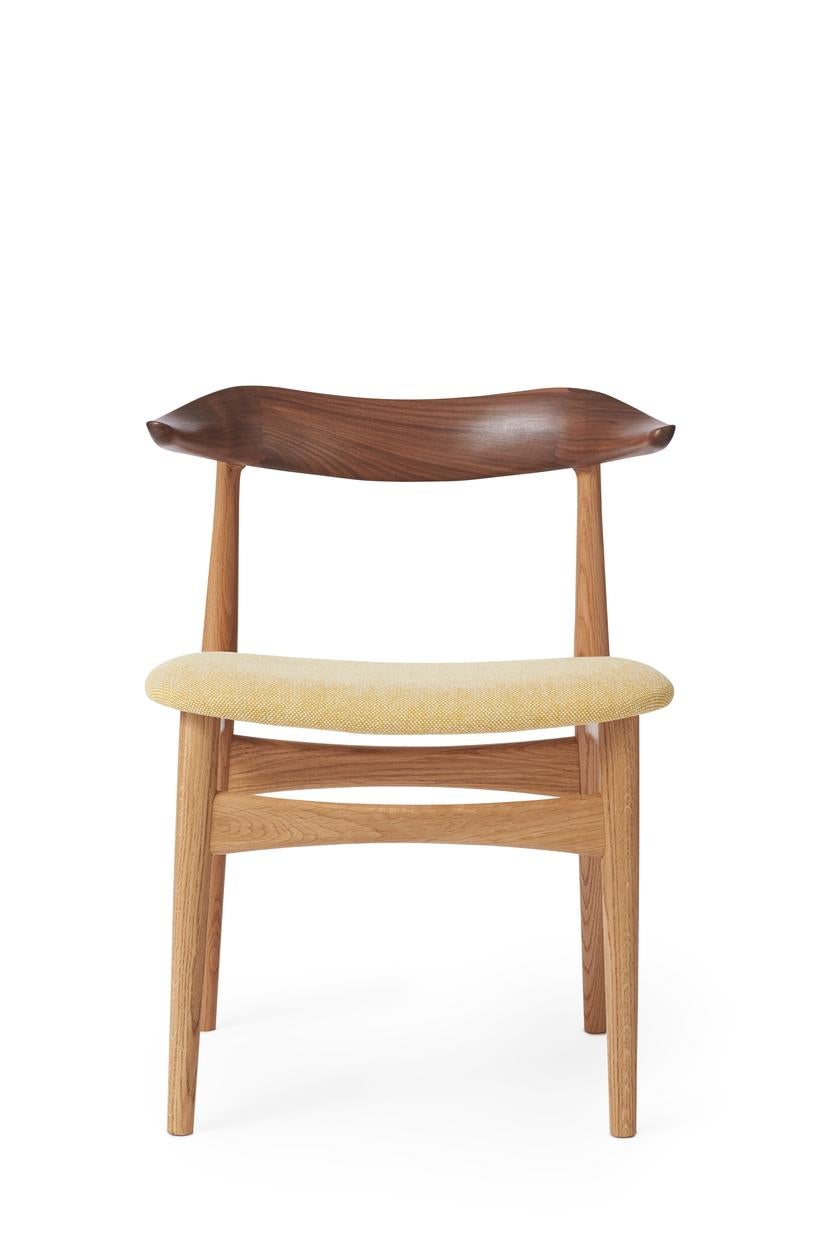 Cow horn chair walnut oak vanilla by Warm Nordic
Dimensions: D55 x W48 x H 74 cm
Material: White oiled solid oak frame, Oiled solid walnut top, Textile or leather upholstery.
Weight: 7.5 kg
Also available in different colors and finishes.