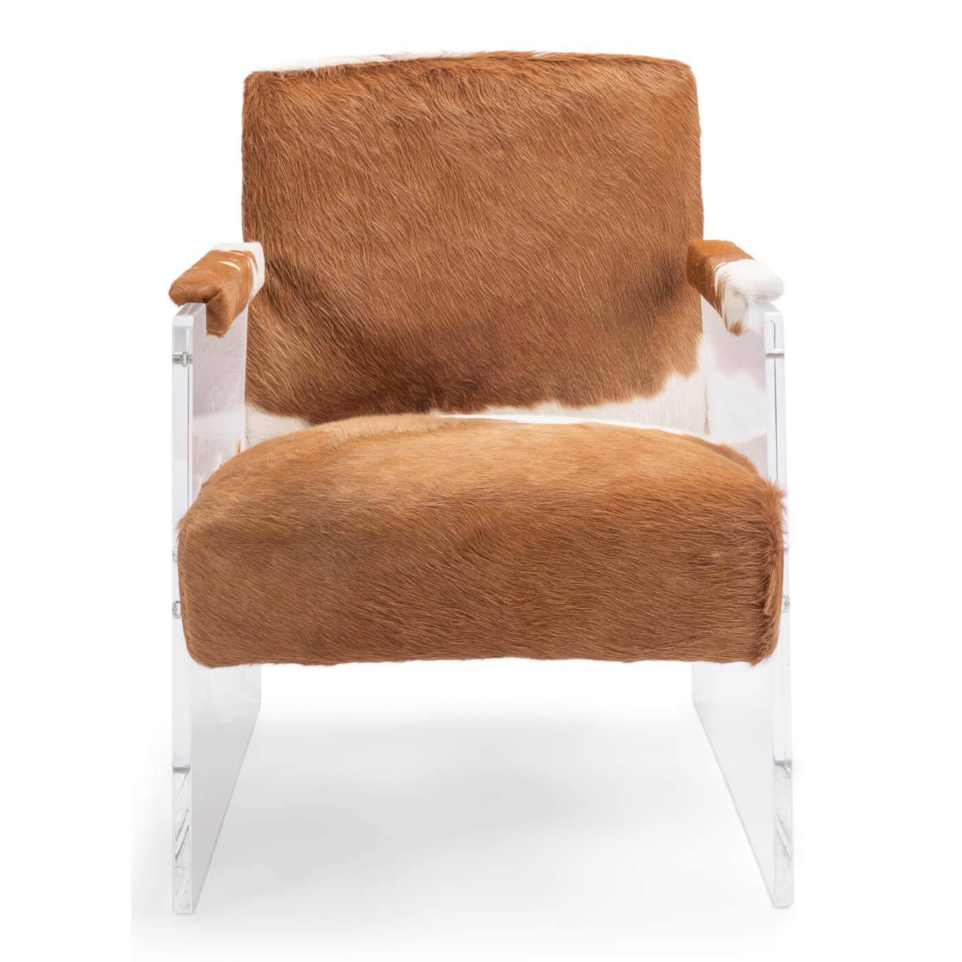 A cowhide and lucite armchair with a modern vintage-western feel, featuring luxe lucite acrylic sides and a brown with white cowhide seat and back. A unique combination of materials makes this piece a true statement piece in any room. Cowhide padded