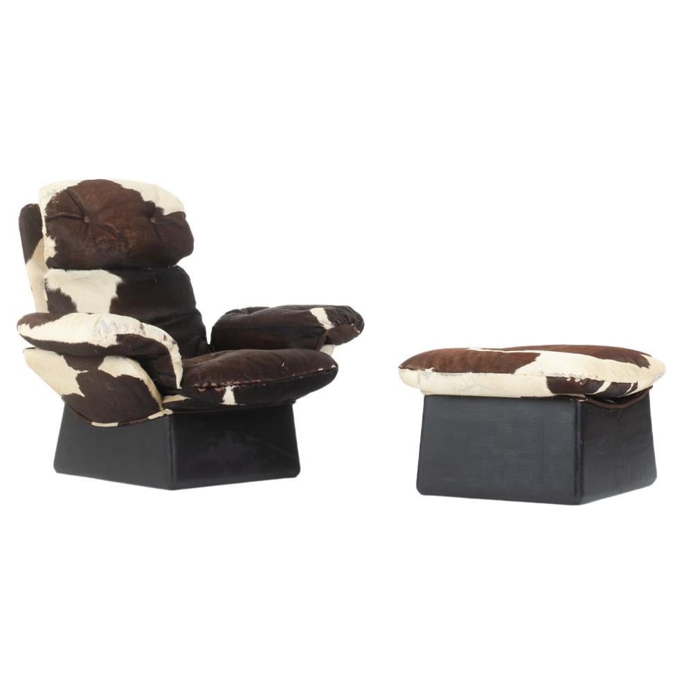 Cowhide armchair and footrest, 1970s For Sale