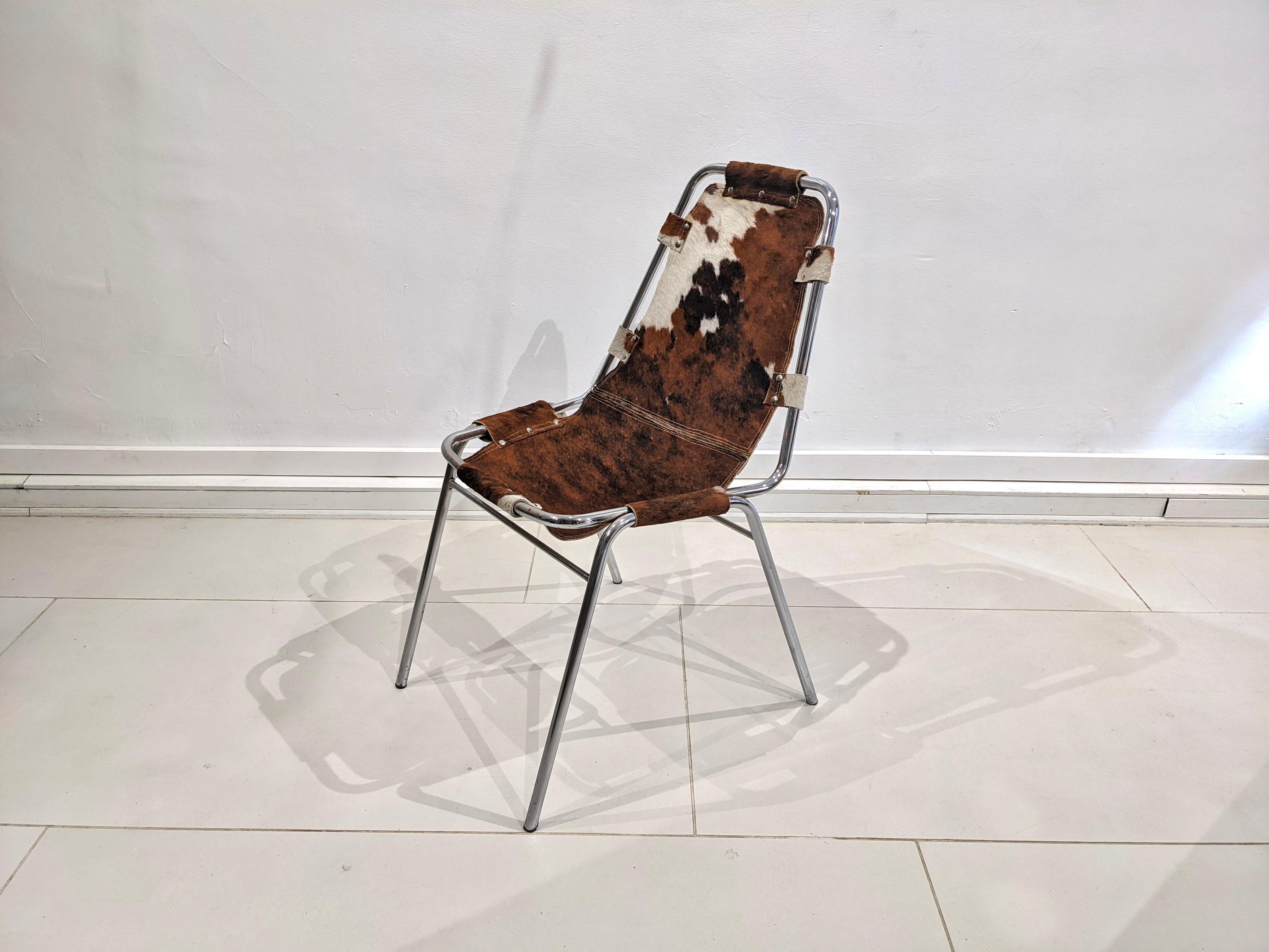 Cowhide chair by Charlotte Perriand for Les Arcs. 
Circa 1960. Good condition. Tubular steel structure and cowhide seat. 
Provenance : Les arcs 1600 - France 

Dimensions : H83 cm x W47 cm x D36 cm.