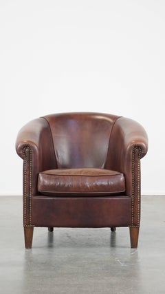 Cowhide club chair in good condition, with rich deep colors in English style