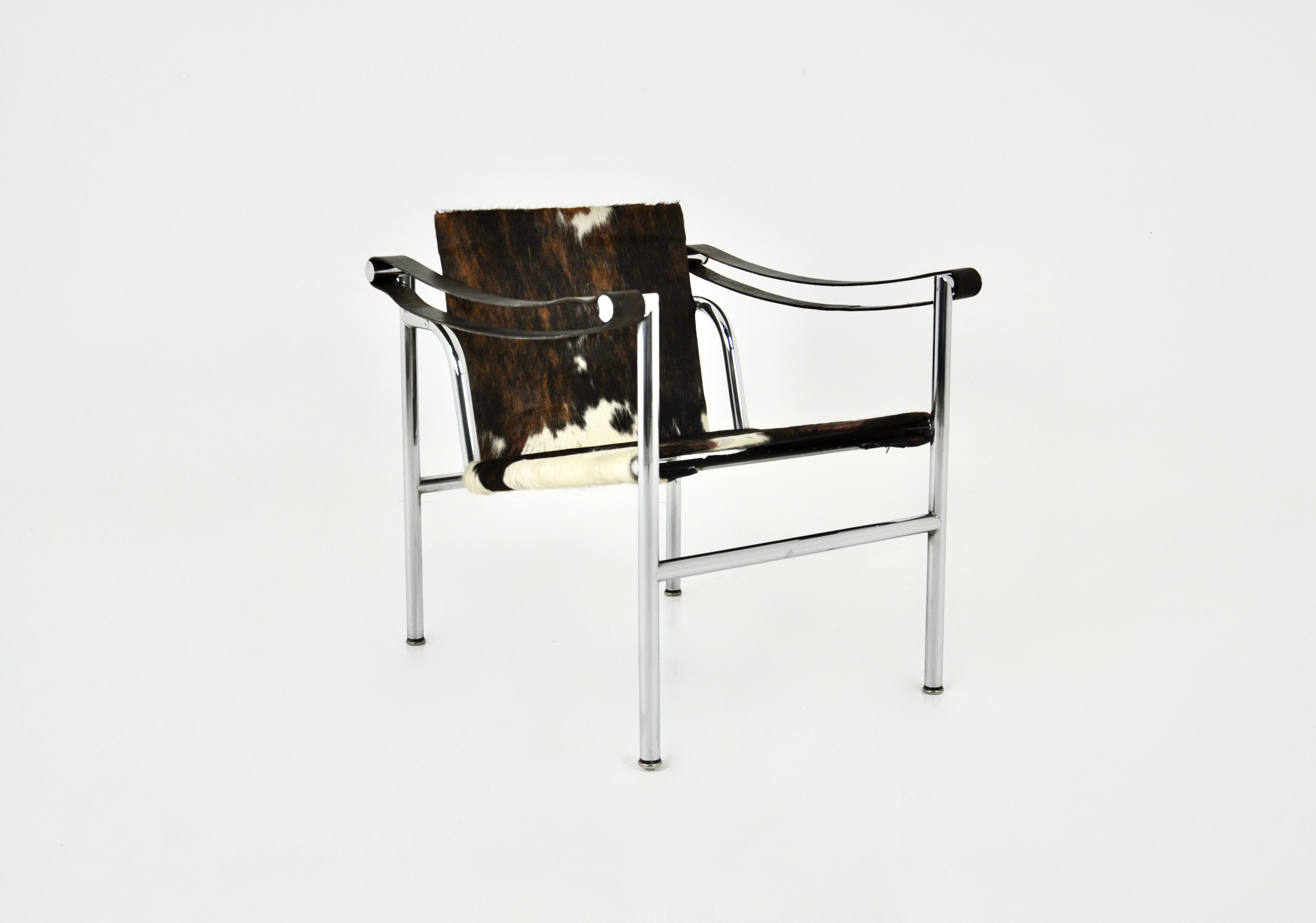 Fauteuil en  en peau de vache et cadre en métal de Le Corbusier. Estampillé Le Corbusier. Hauteur du siège : 39 cm. Usure due au temps et à l'âge du fauteuil.