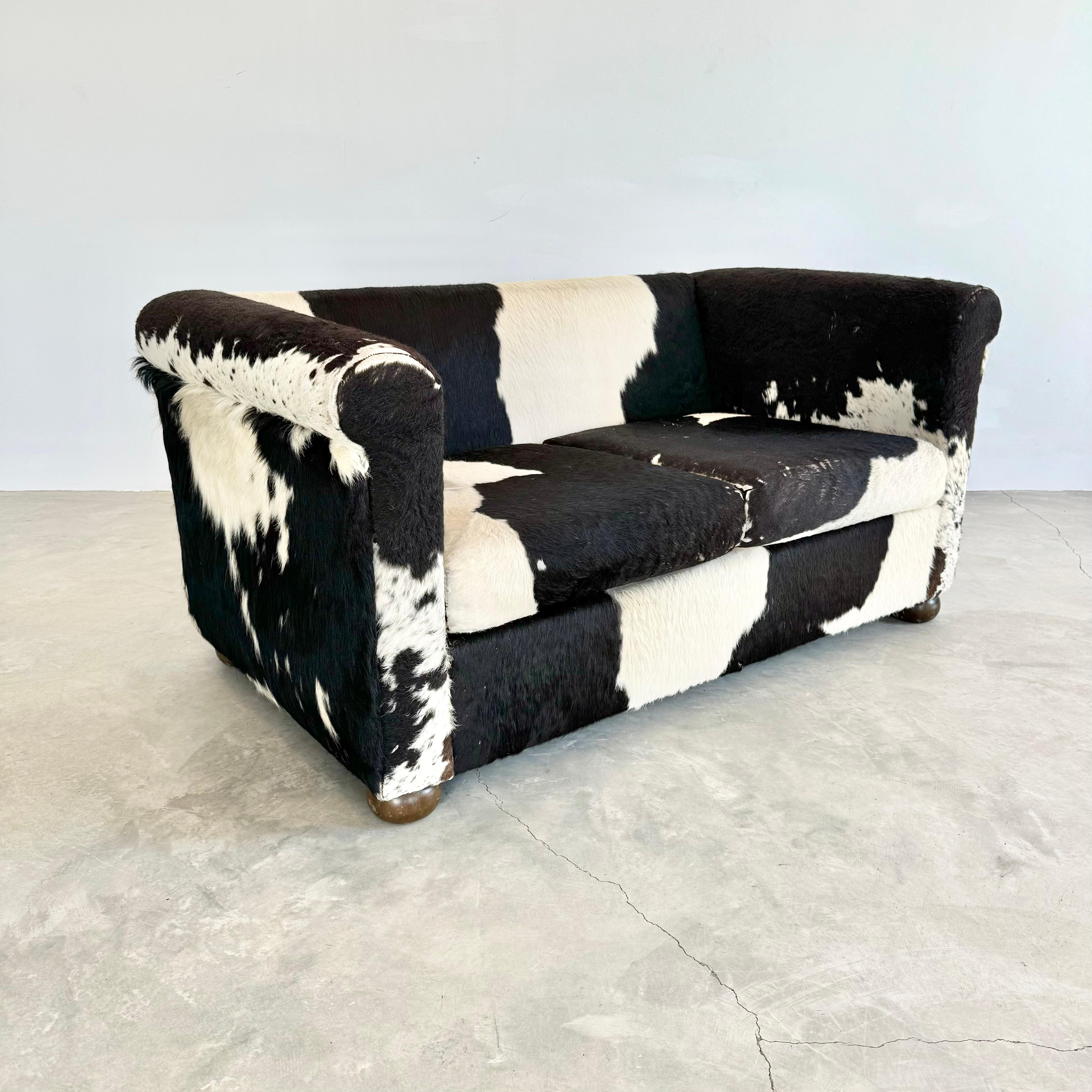 Incredible 2 seat cowhide sofa in black and white. Great coloring and contrast within the sofa as well as fluctuations in the nap and length of the hair with some sections being more worn in and others being longer and shaggy. Very comfortable and