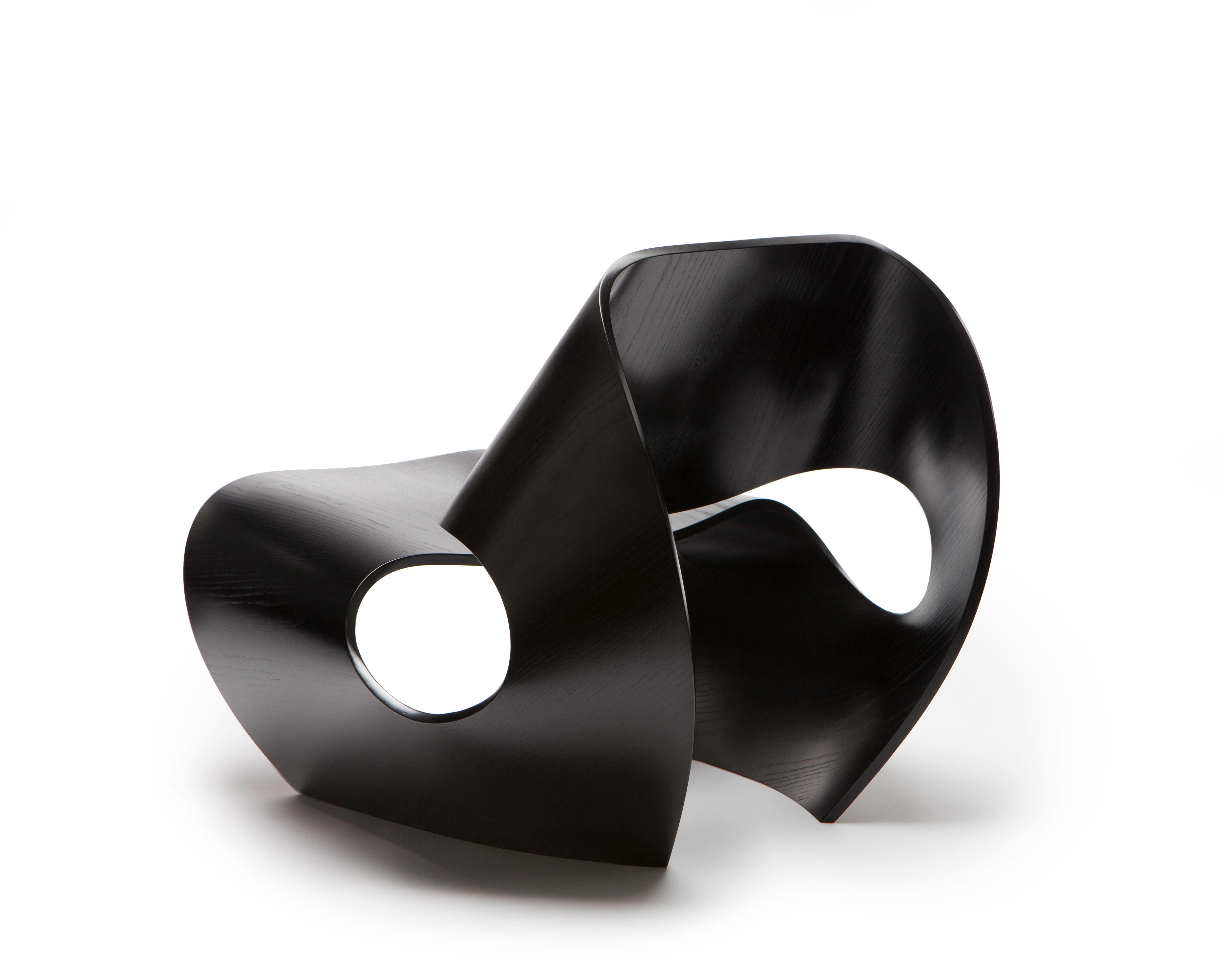 La chaise Cowrie contemporaine est une chaise facile solide comme le roc, inspirée par les lignes concaves des coquillages. Les formes curvilignes sont le résultat d'un processus de recherche et d'innovation approfondi qui jette un pont entre le