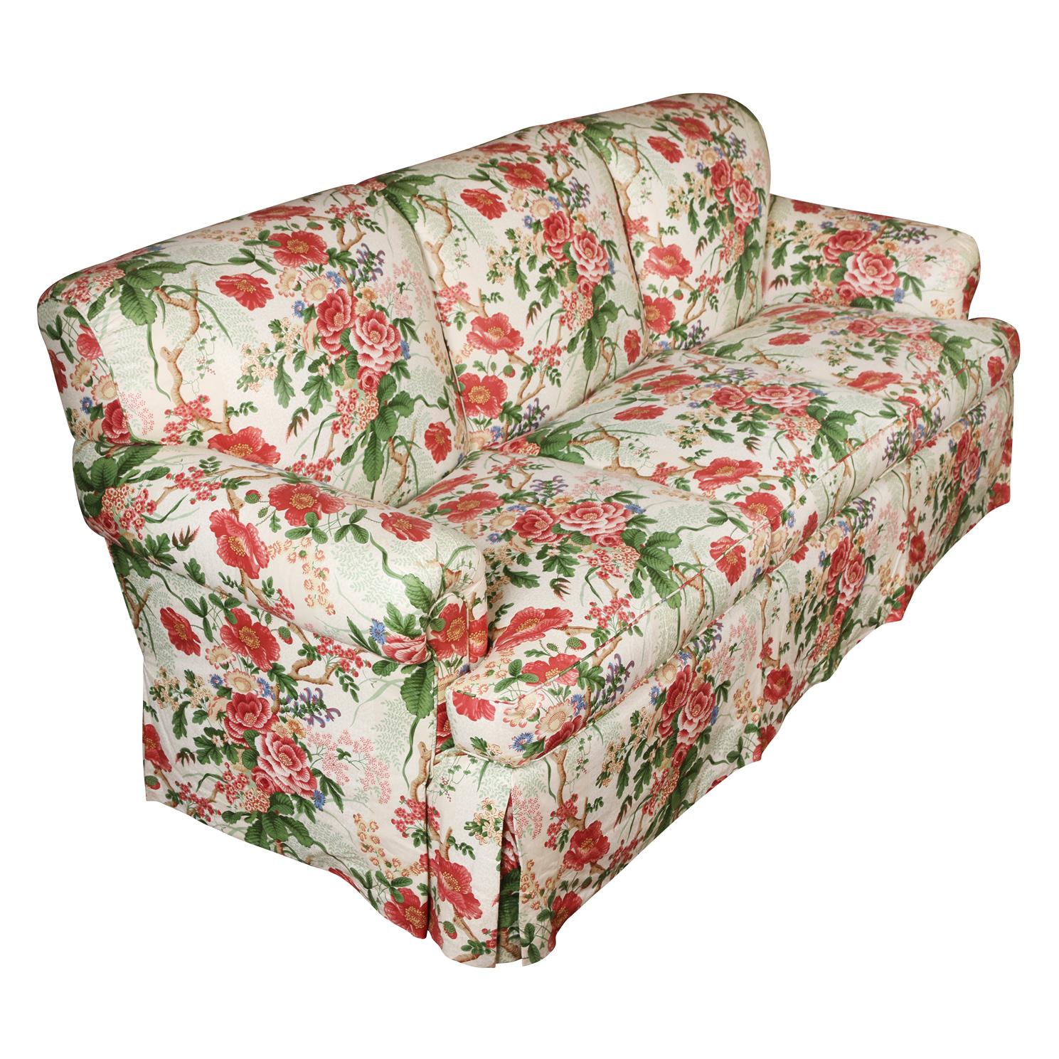 Cowtan & Tout upholstered floral three cushion, roll arm English sofa in red, pink and green.