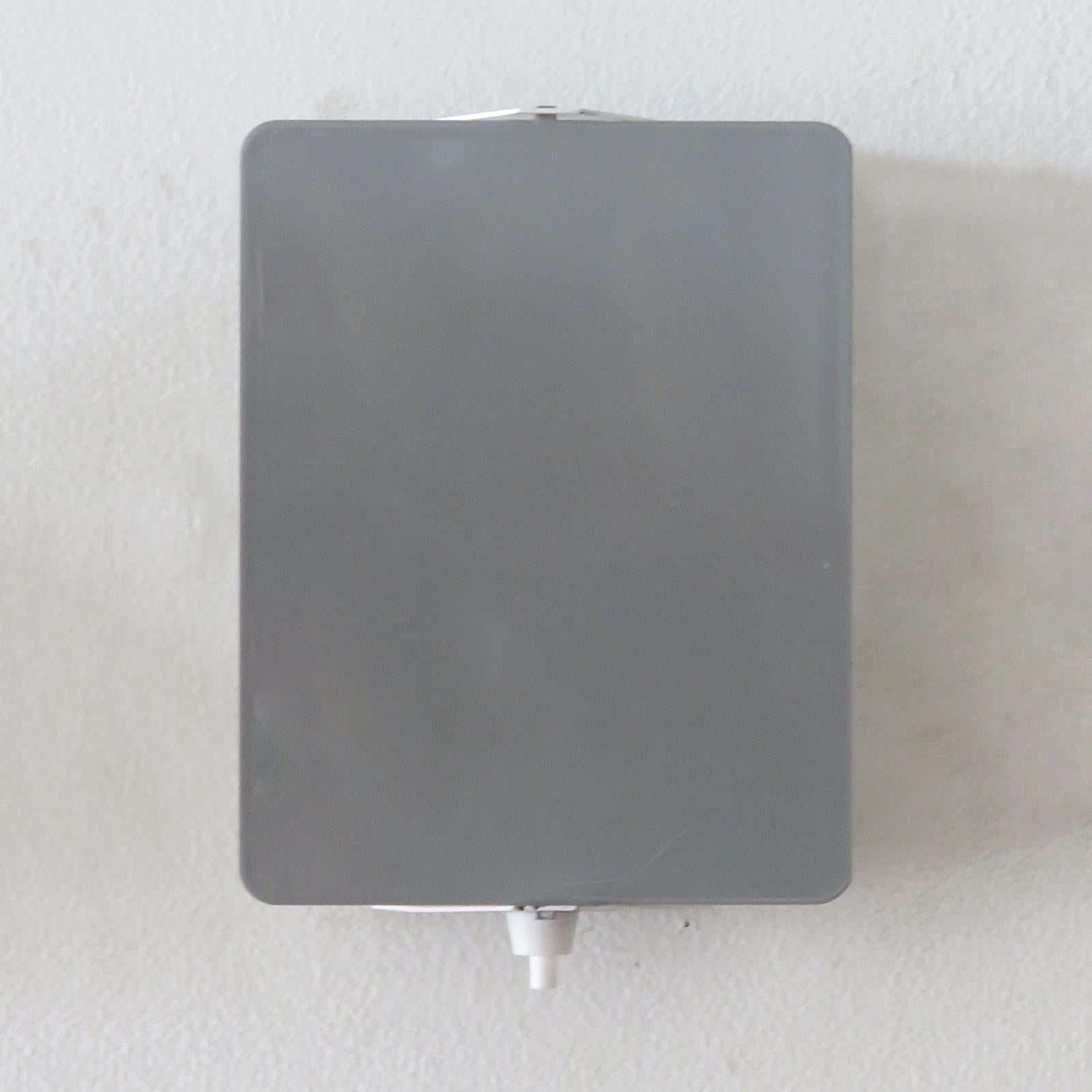 Iconic enameled wall lights by Charlotte Perriand with adjustable reflectors in rare grey finish, optional horizontal or vertical mount, manufactured and distributed by Steph Simon, Paris, marked, shown on an optional powder coated mounting plate to
