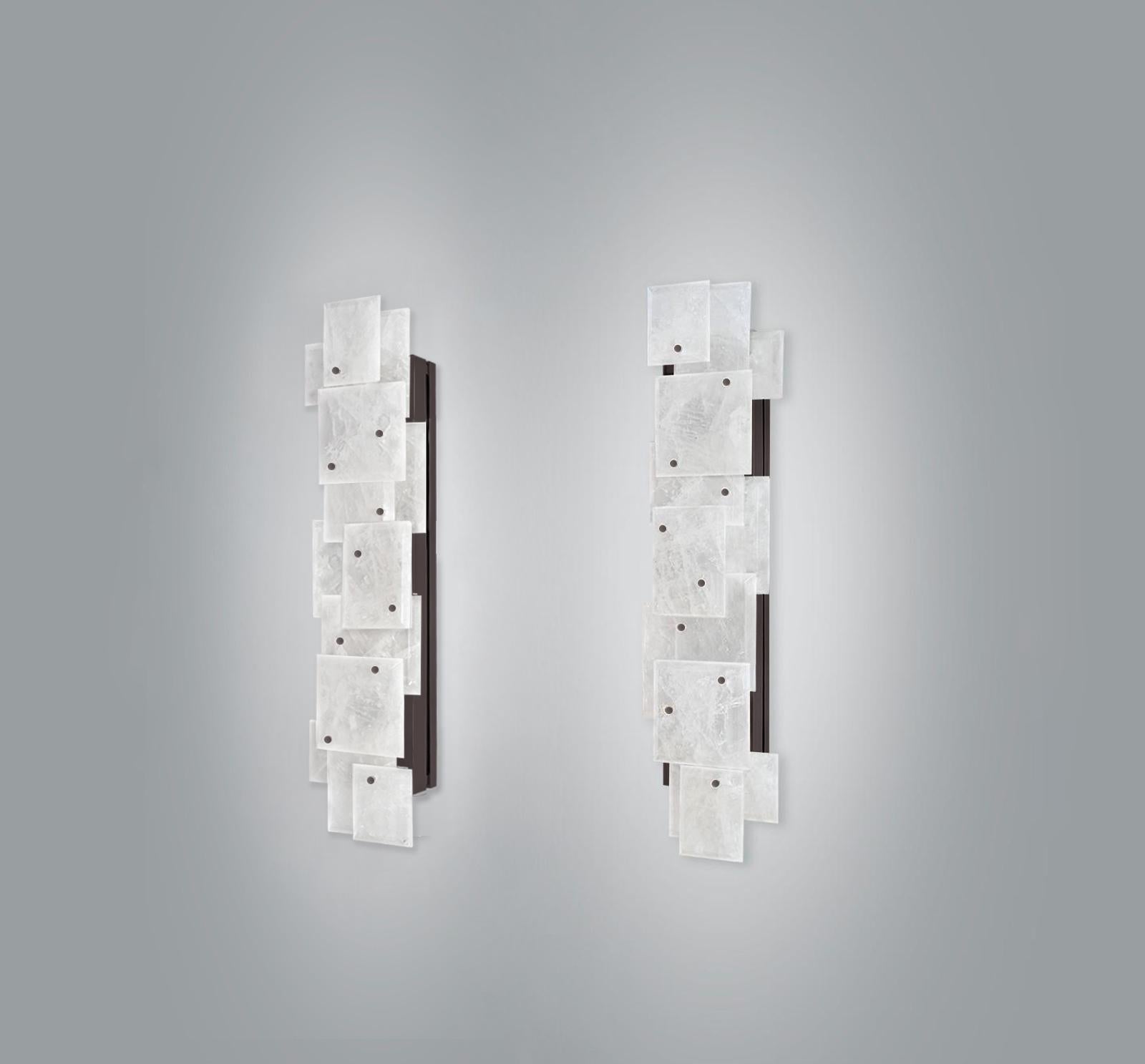 Coppia di moderne appliques in cristallo di rocca con decorazioni a pannelli multipli in finitura ottone antico. Creato da Phoenix Gallery.
Ogni applique ha installato quattro prese, utilizza quattro lampadine a luce calda Led da 75 watt, per un