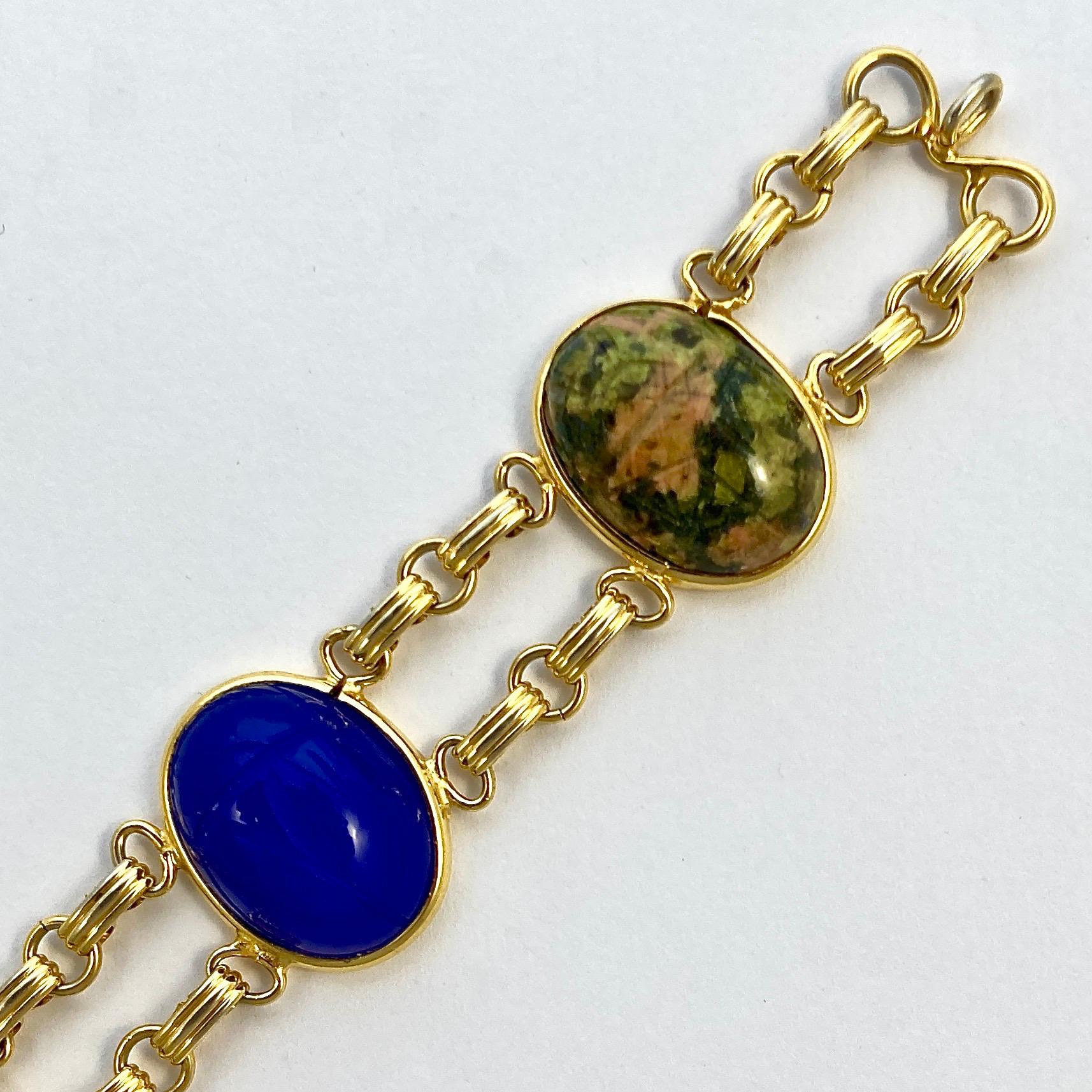 Charles Reis Company 12K gold filled vintage bracelet with a safety chain, featuring large engraved scarabs on semi precious stones, including tiger eye, blue chalcedony, and carnelian. Length 19.5cm / 7.5 inches by width 2.1cm / .8 inch. The