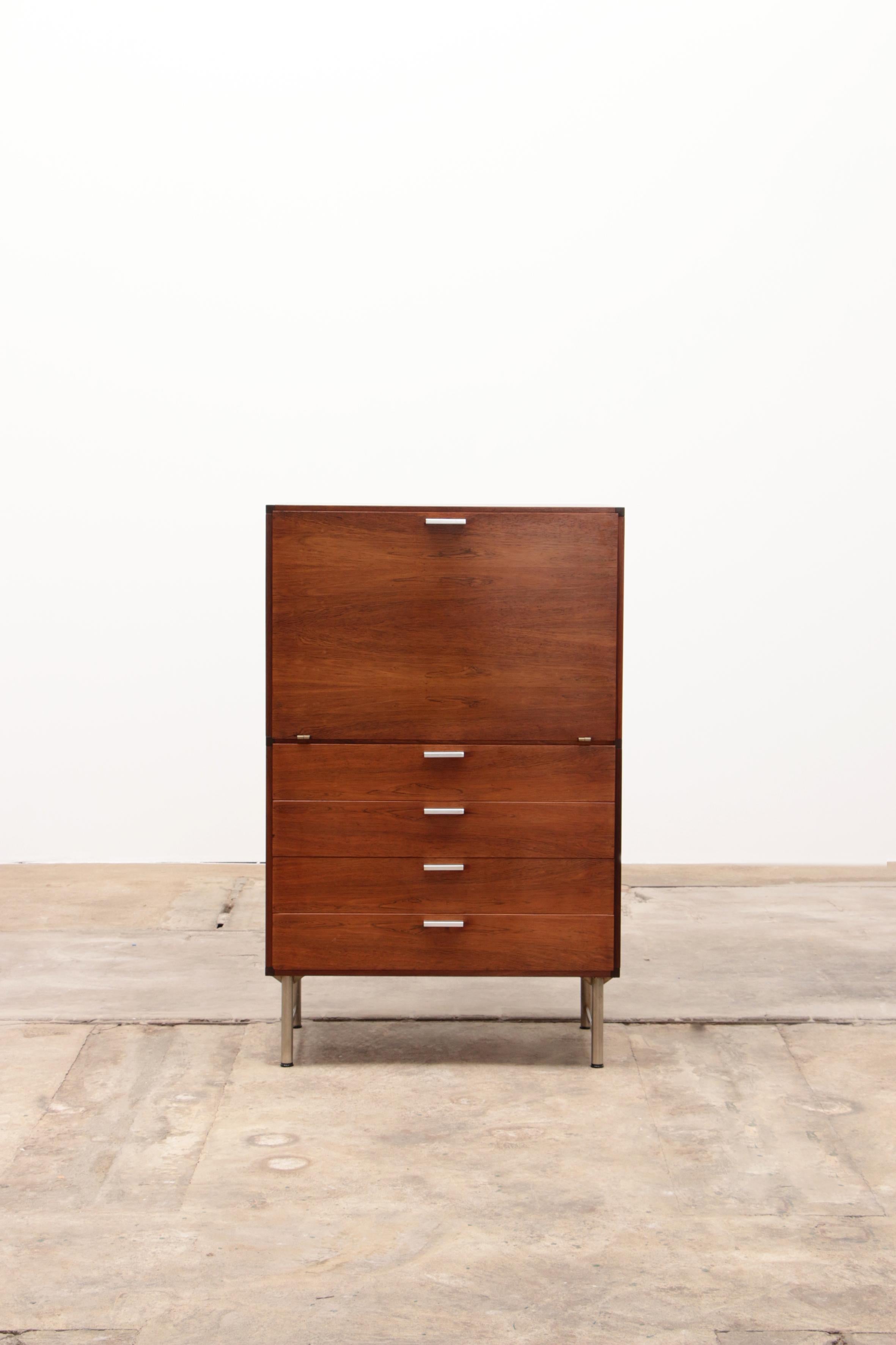 Rare Pastoe liquor cabinet designed by Cees Braakman in the 1960s. The cabinet is made of wenge wood and stands on a sleek metal base. This version contains four drawers and a flap door. The top compartment contains a dark colored glass plate and