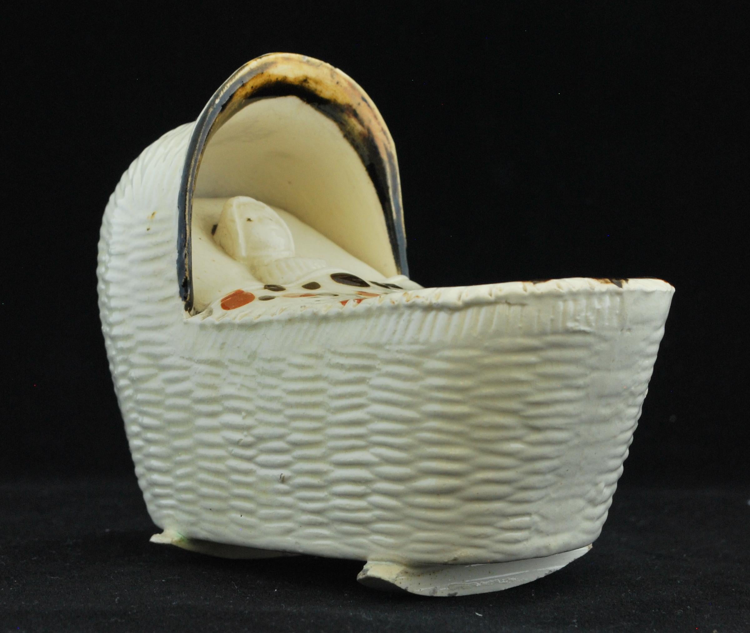 A very fine example in creamware of an infant swaddled and lying in its crib. 

These miniature representations served various purposes:

Decorative objects: Miniature models of infants in cribs were often crafted as decorative items for display in