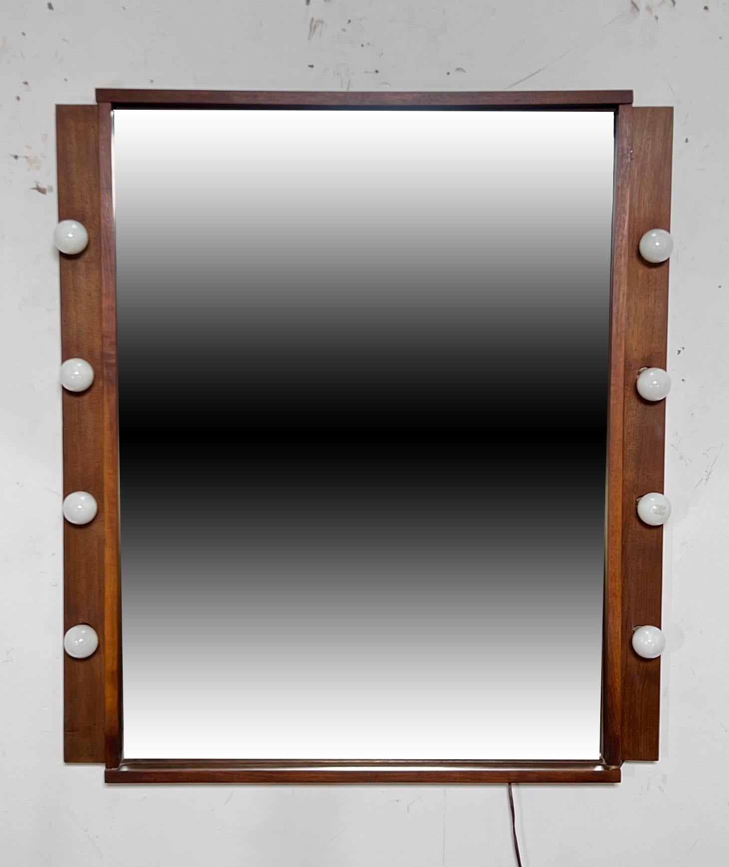 A craft made walnut bedroom mirror with vanity bulb surround, circa 1960s

Depth of 4.5