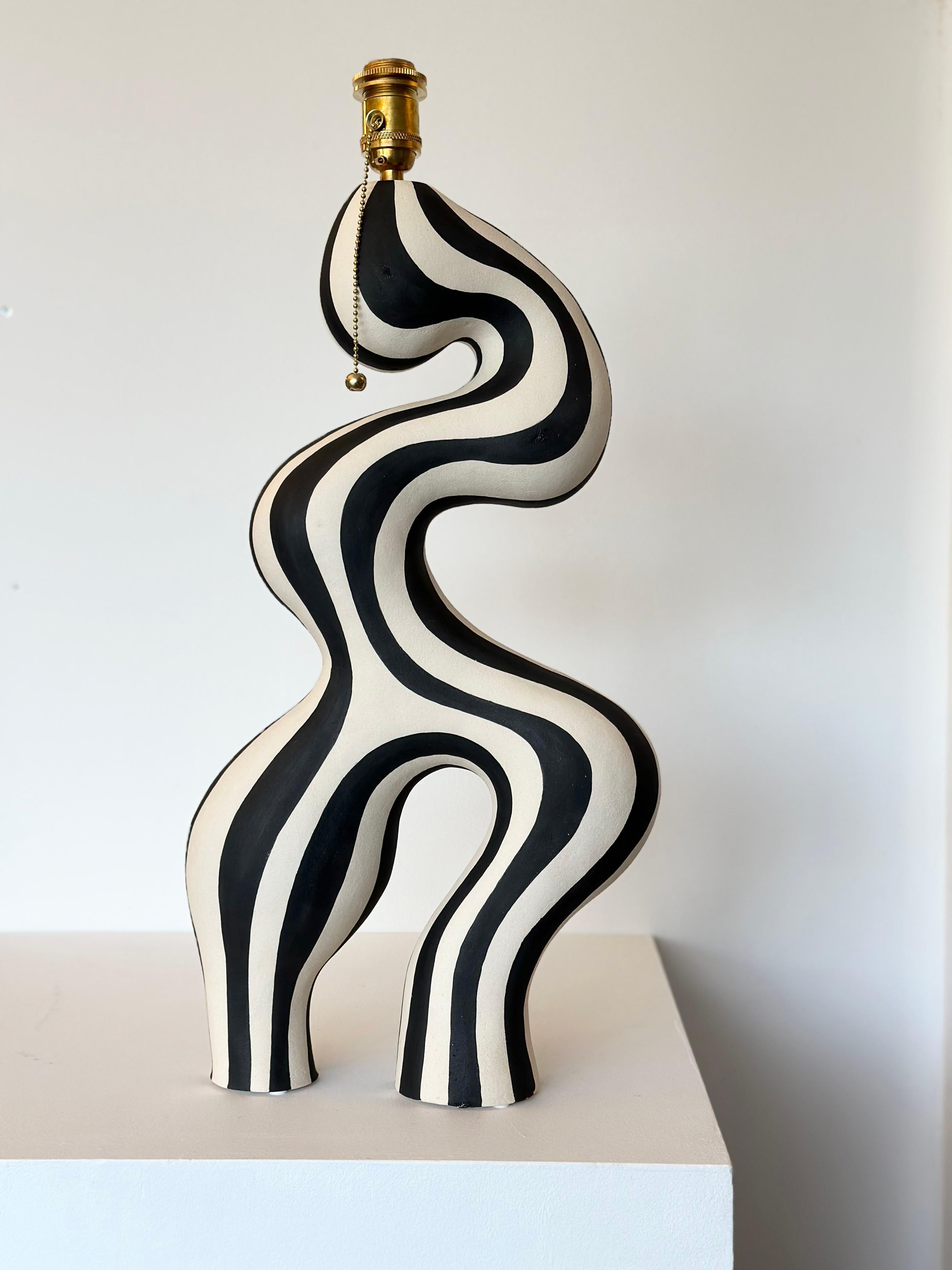 A statement piece designed and handcrafted by ceramic artist Johanne Birkeland who works under the artist name Jossolini. The lamp base is hand built in white stoneware clay, and hand decorated with black matte glaze. 

The Norwegian artist works