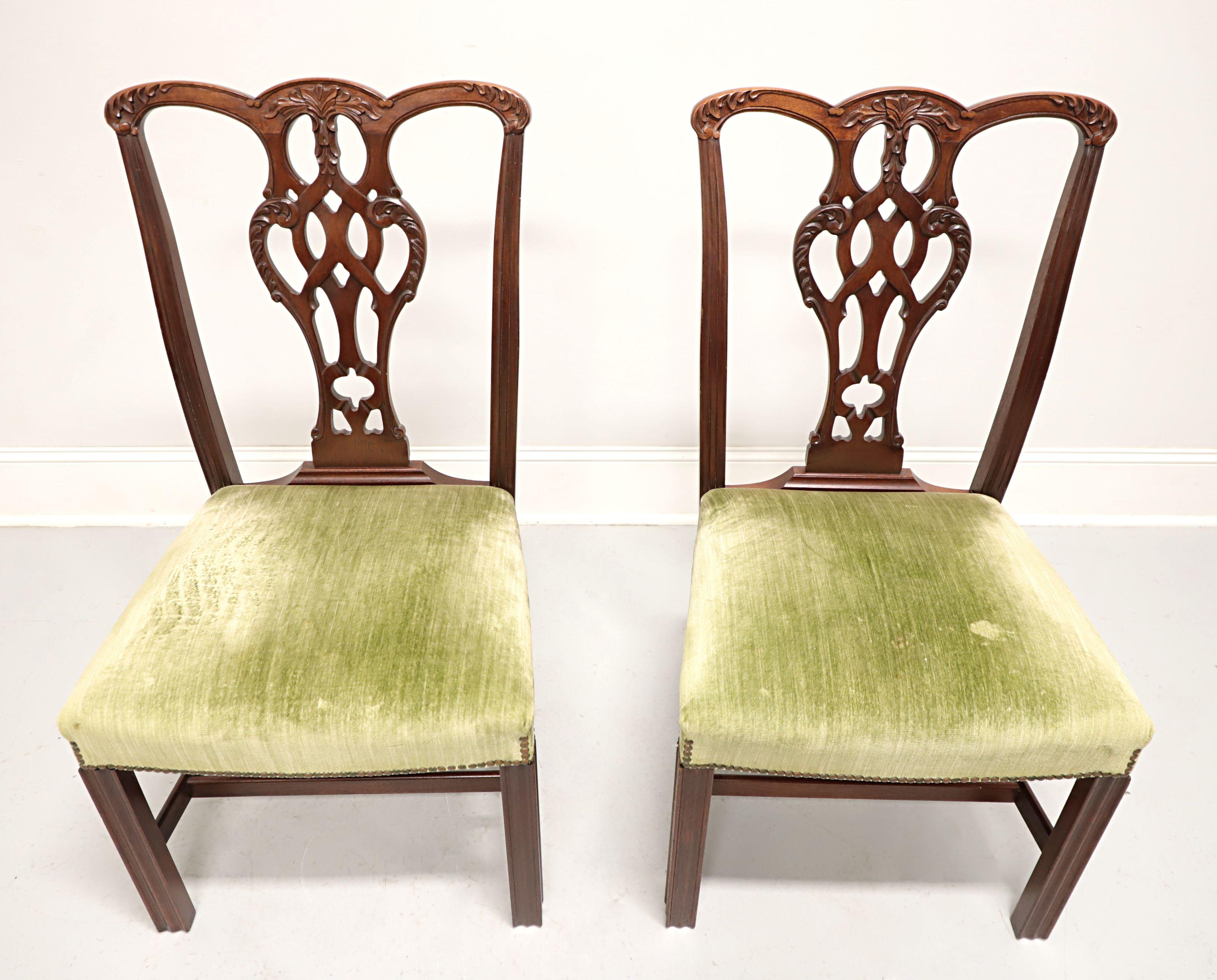 A pair of Chippendale style dining side chairs by high-quality furniture maker Craftique. Solid mahogany with their English Mahogany finish, decoratively carved crest rail, back rest, fluted stiles, and straight fluted front legs with stretchers.