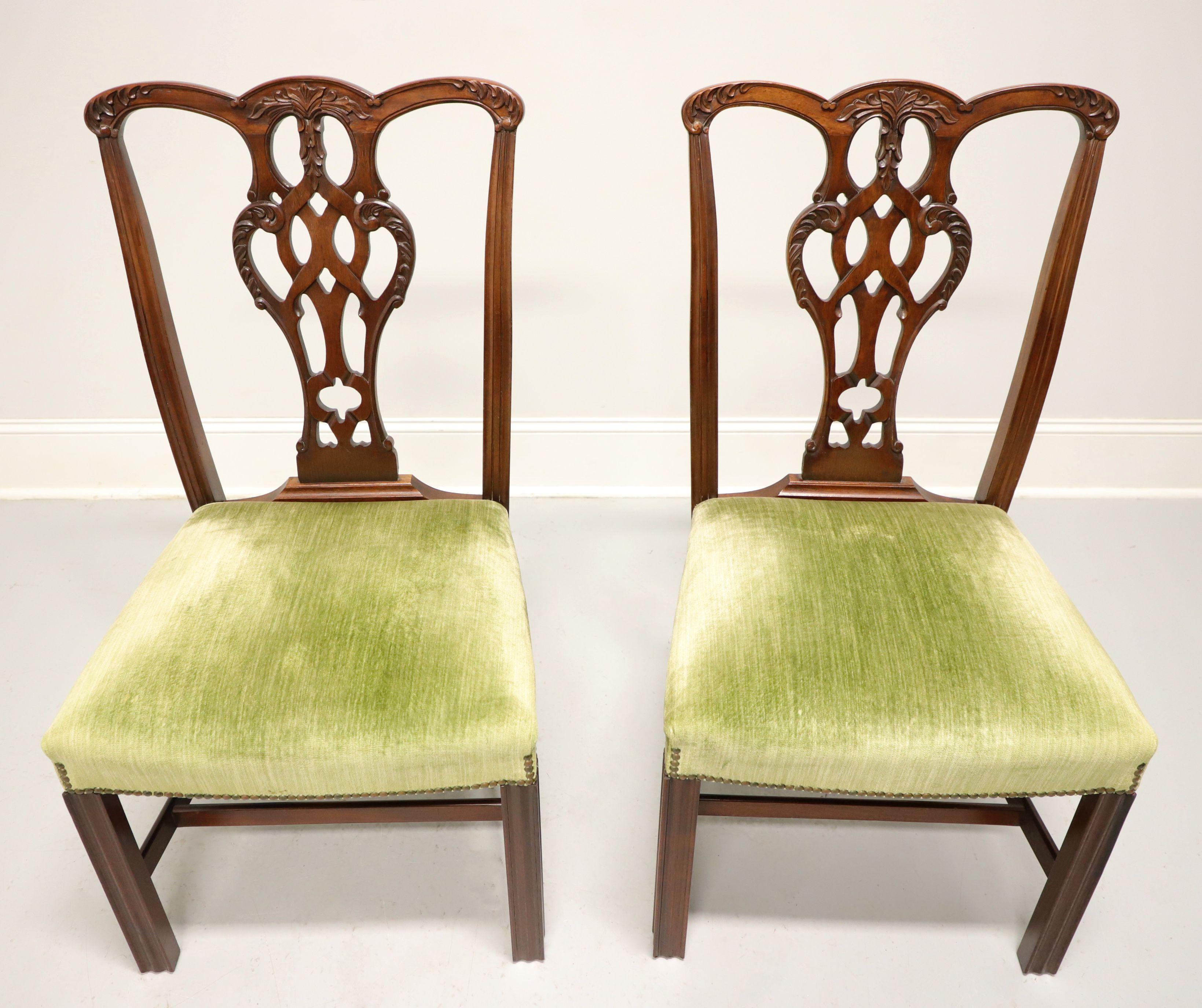 A pair of Chippendale style dining side chairs by high-quality furniture maker Craftique. Solid mahogany with their English Mahogany finish, decoratively carved crest rail, back rest, fluted stiles, and straight fluted front legs with stretchers.