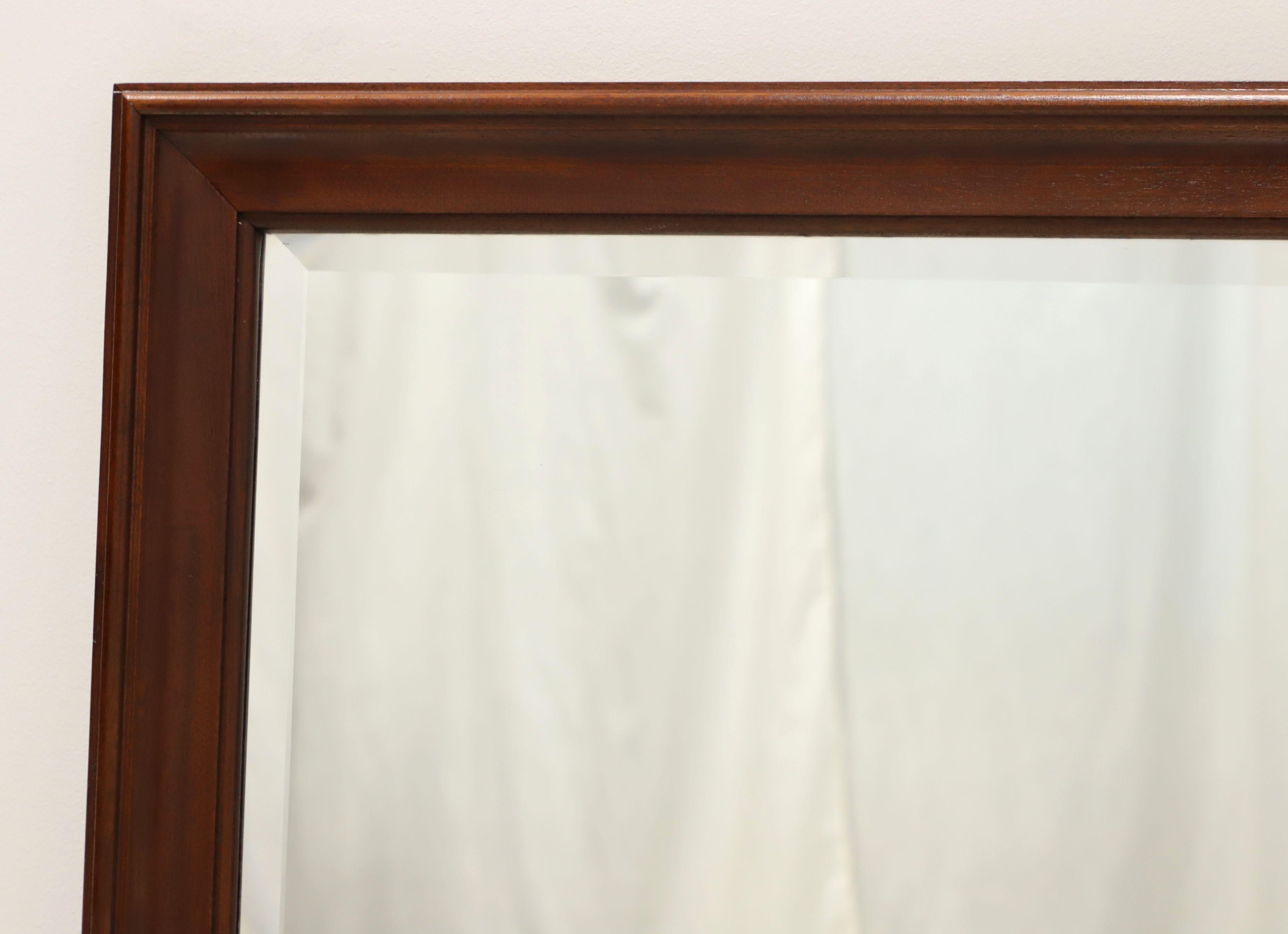 A Traditional style rectangular dresser or wall mirror by top-quality furniture maker Craftique. Beveled mirror glass in a solid mahogany frame with their Mellowax finish. Made in Mebane, North Carolina, USA, in the late 20th Century.

Measures: