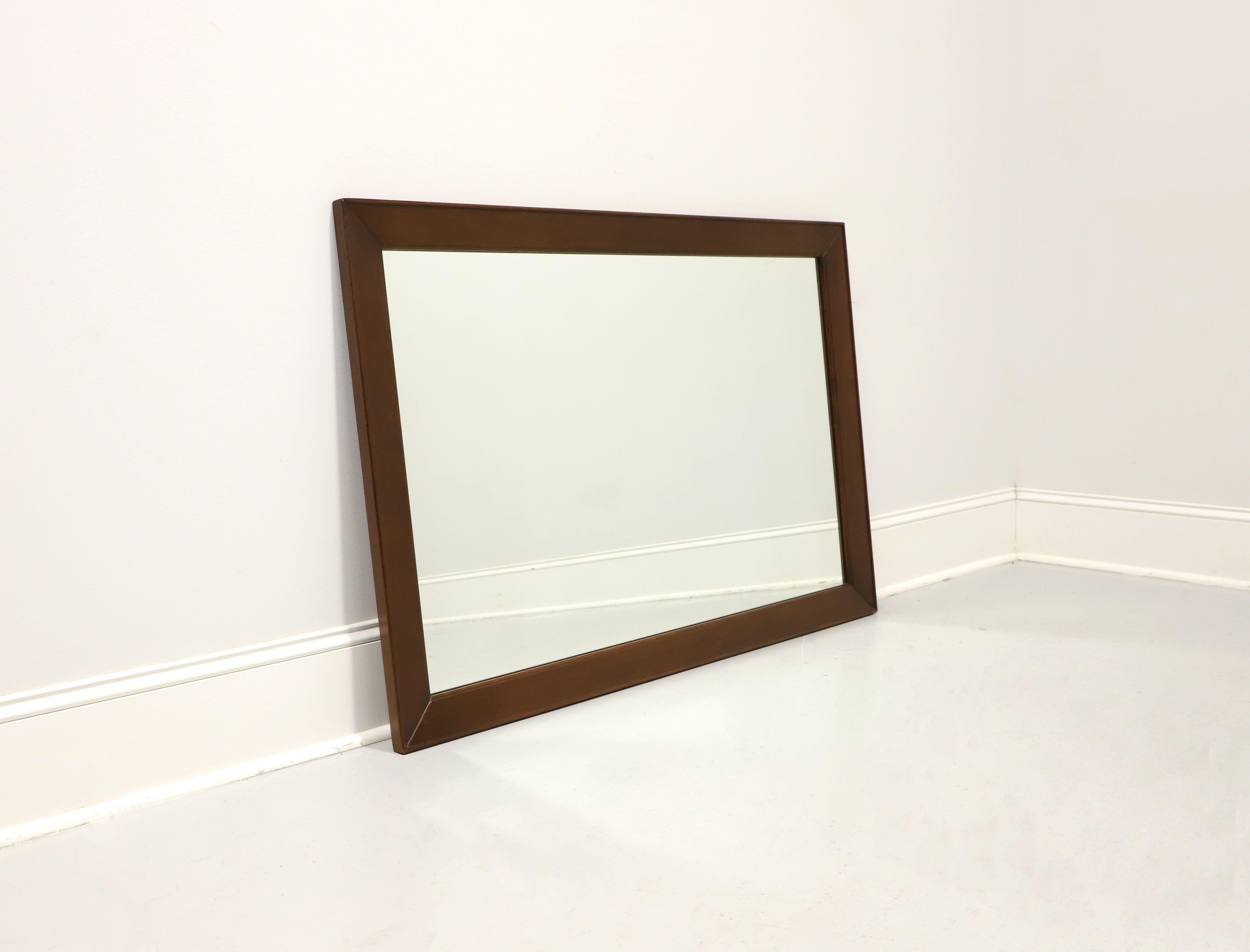 A Traditional style rectangular dresser or wall mirror by high-quality furniture maker Craftique. Mirror glass in a solid mahogany frame with a smooth eased edge and their Old Wood finish. Made in Mebane, North Carolina, USA, in the late 20th