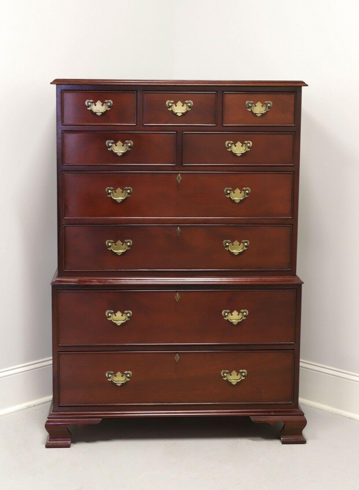 A Chippendale style chest on chest by Craftique, of Mebane, North Carolina, USA. Solid Mahogany with brass drawer pulls, escutcheons and ogee bracket feet. Features nine various size drawers of dovetail construction, four larger being lockable.