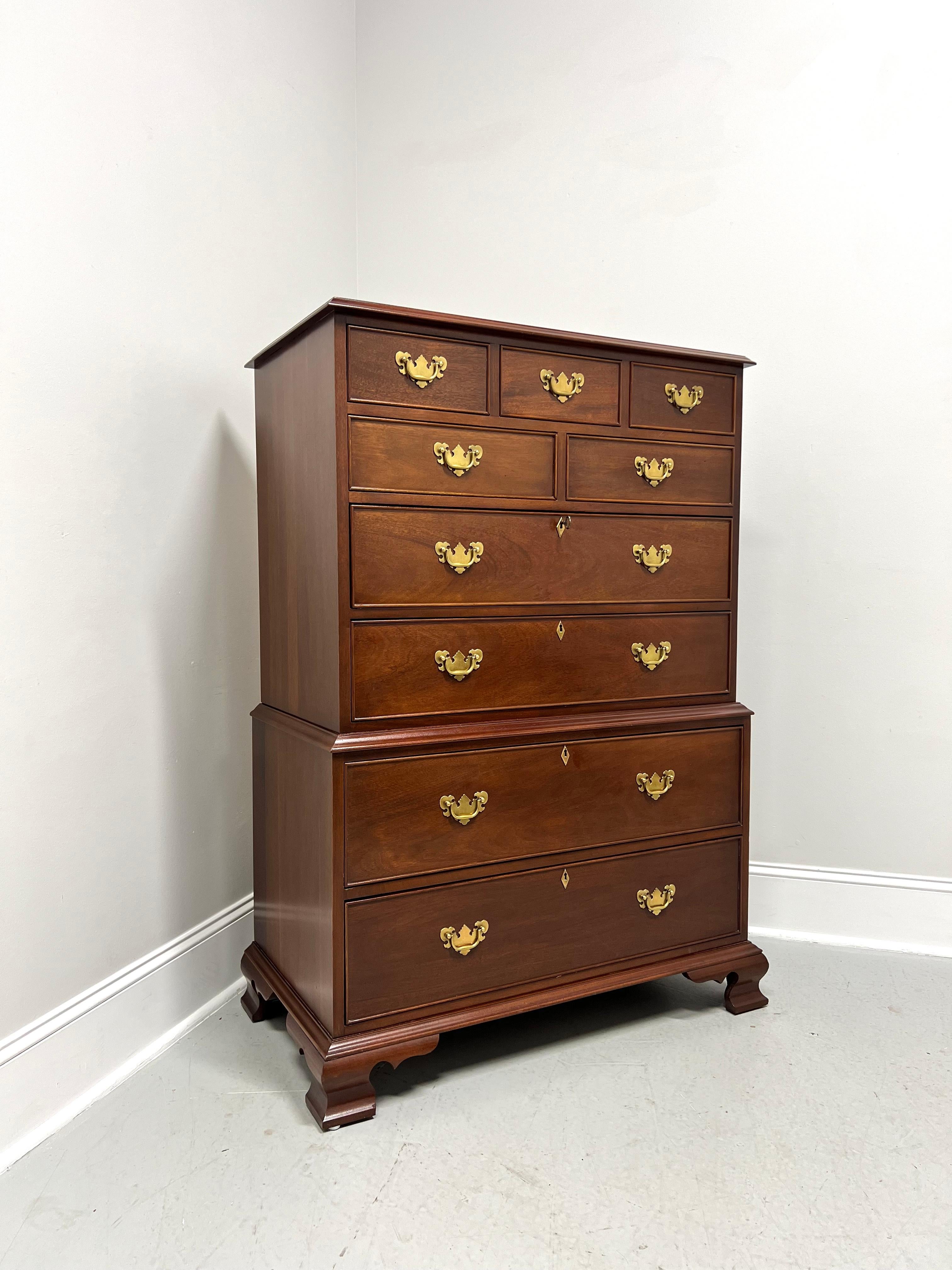 A Chippendale style chest on chest by high-quality furniture maker Craftique. Solid mahogany with their Old Wood finish, brass hardware, ogee edge to the top, brass keyhole escutcheons, and ogee bracket feet. Features nine various size drawers of