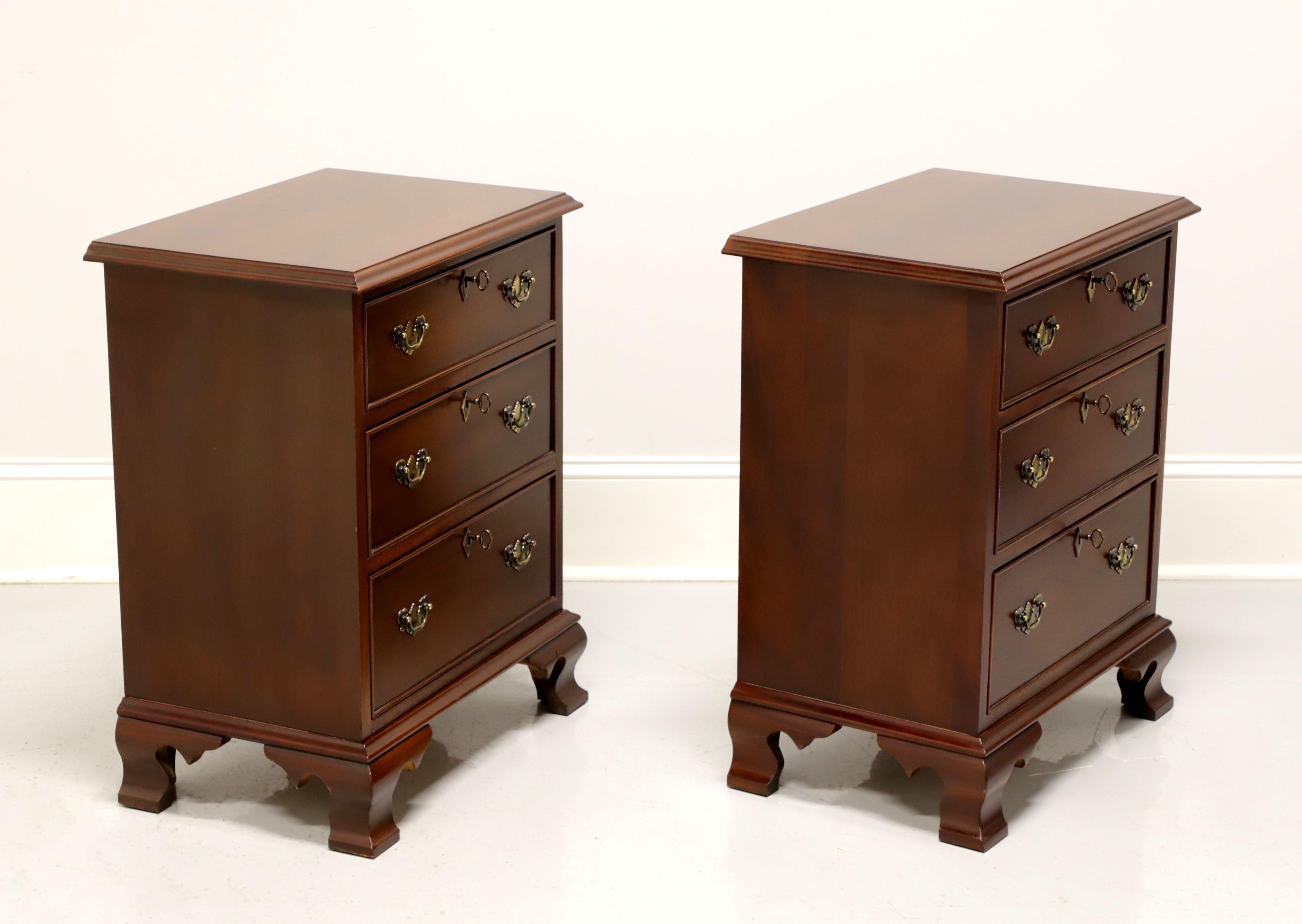 A pair of Chippendale style nightstands by Craftique, of Mebane, North Carolina, USA. Solid mahogany with brass hardware and ogee bracket feet. Features three lockable drawers of dovetail construction. Includes three keys per nightstand. Made in the