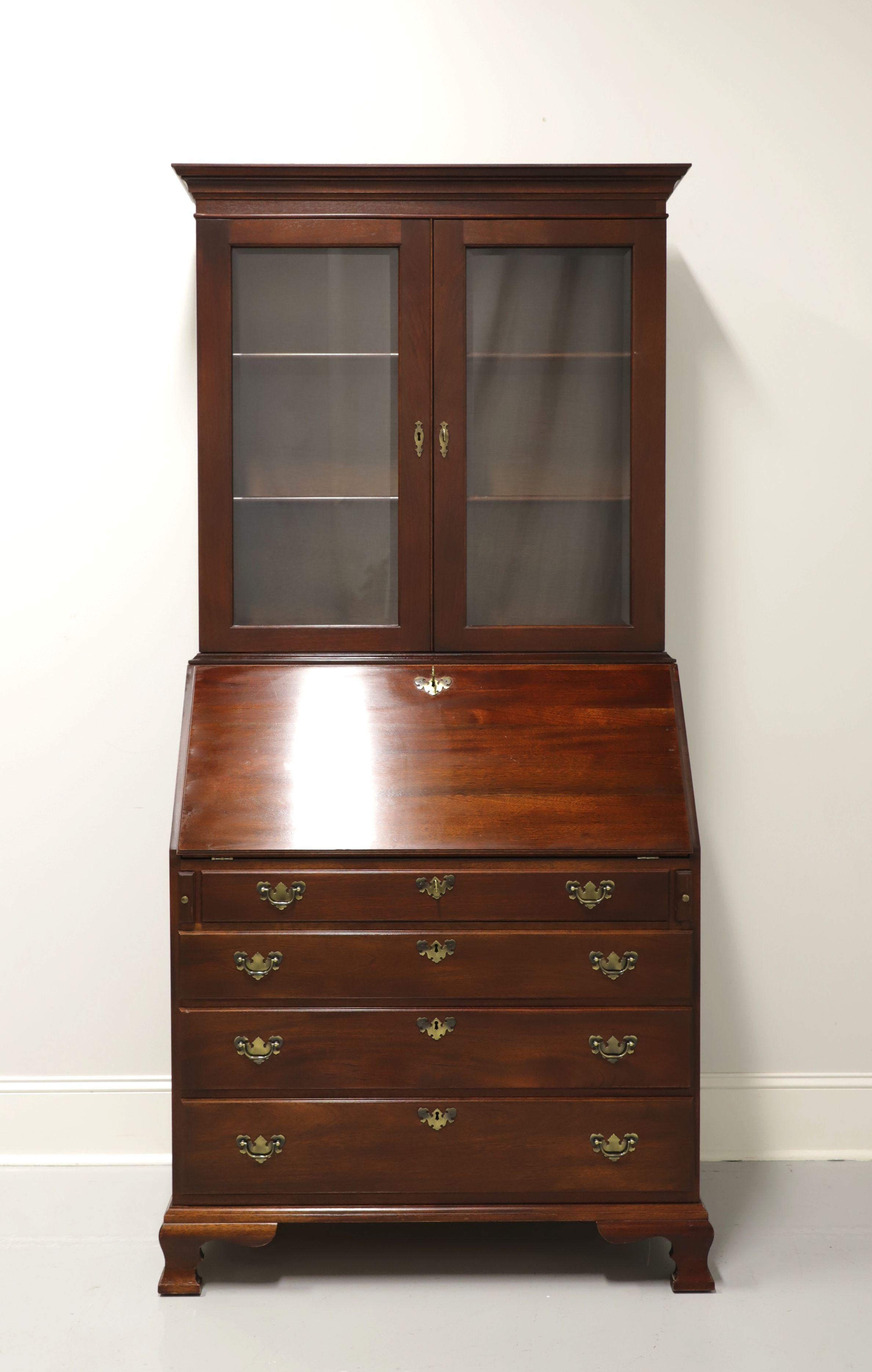 A stunning secretary desk with bookcase by top-quality furniture maker Craftique, in the style of early American John Hancock desks. Solid mahogany with brass hardware. Features upper bookcase with two fixed wooden shelves and is lockable. Lower