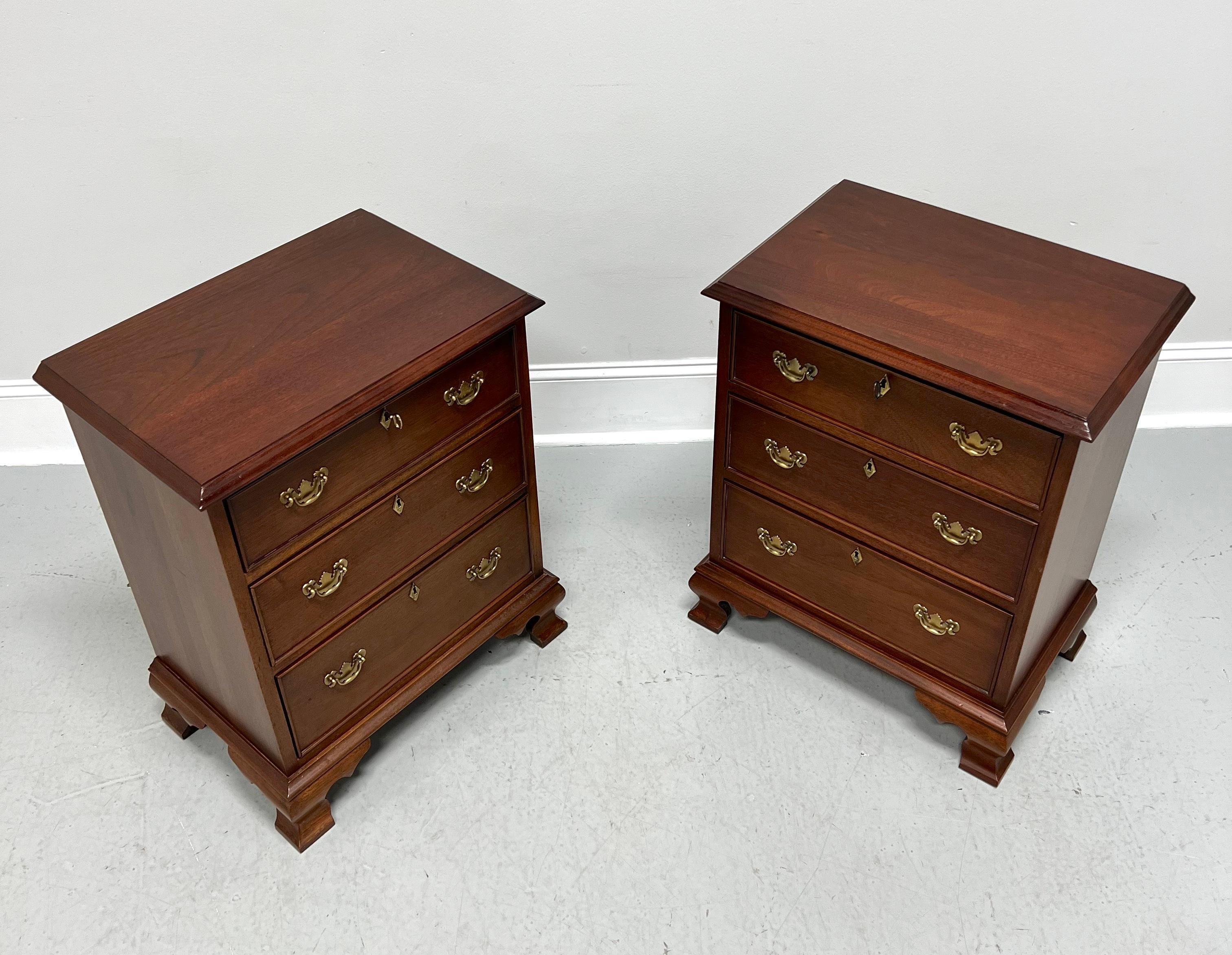 A pair of Chippendale style nightstands by high-quality furniture maker Craftique. Solid mahogany with their Old Wood finish, brass hardware, ogee edge to top, brass keyhole escutcheons, and ogee bracket feet. Features three lockable drawers of