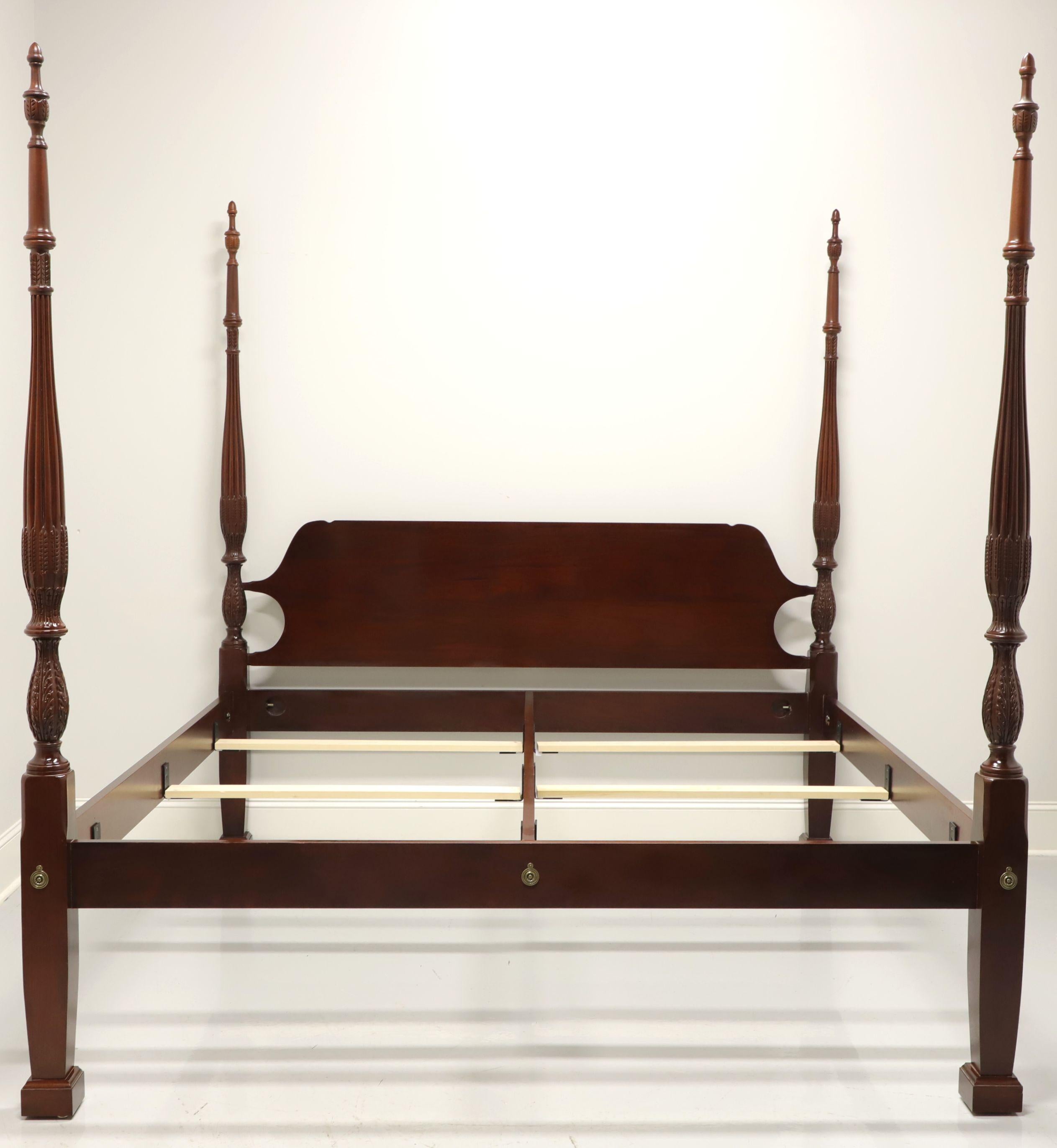 A Traditional style king size poster bed by Craftique, of Mebane, North Carolina, USA. Solid mahogany with four rice carved posts with finials and brass hardware. Wood slats affix to metal brackets on center rail and side rails for mattress support.