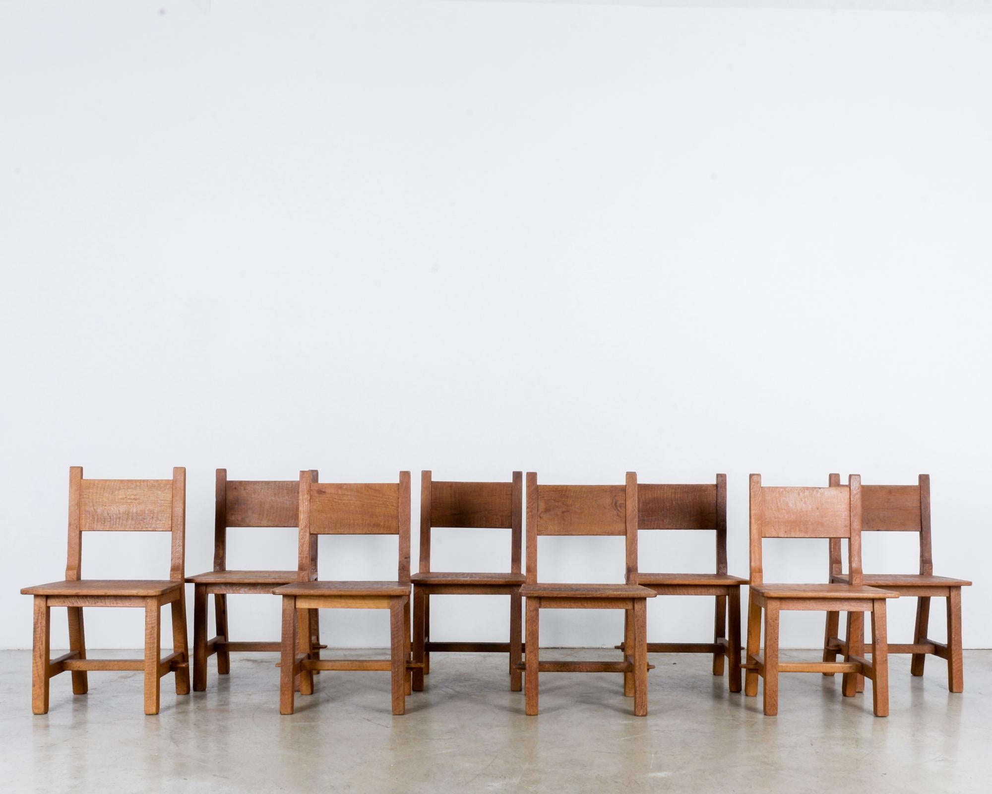 This set of eight wooden dining chairs was made in Belgium, circa 1960. These chairs are emblematic of the tactile and handmade characteristics of 1960s design. The polished wood exudes warmth, and the chairs are fabricated to display its highly