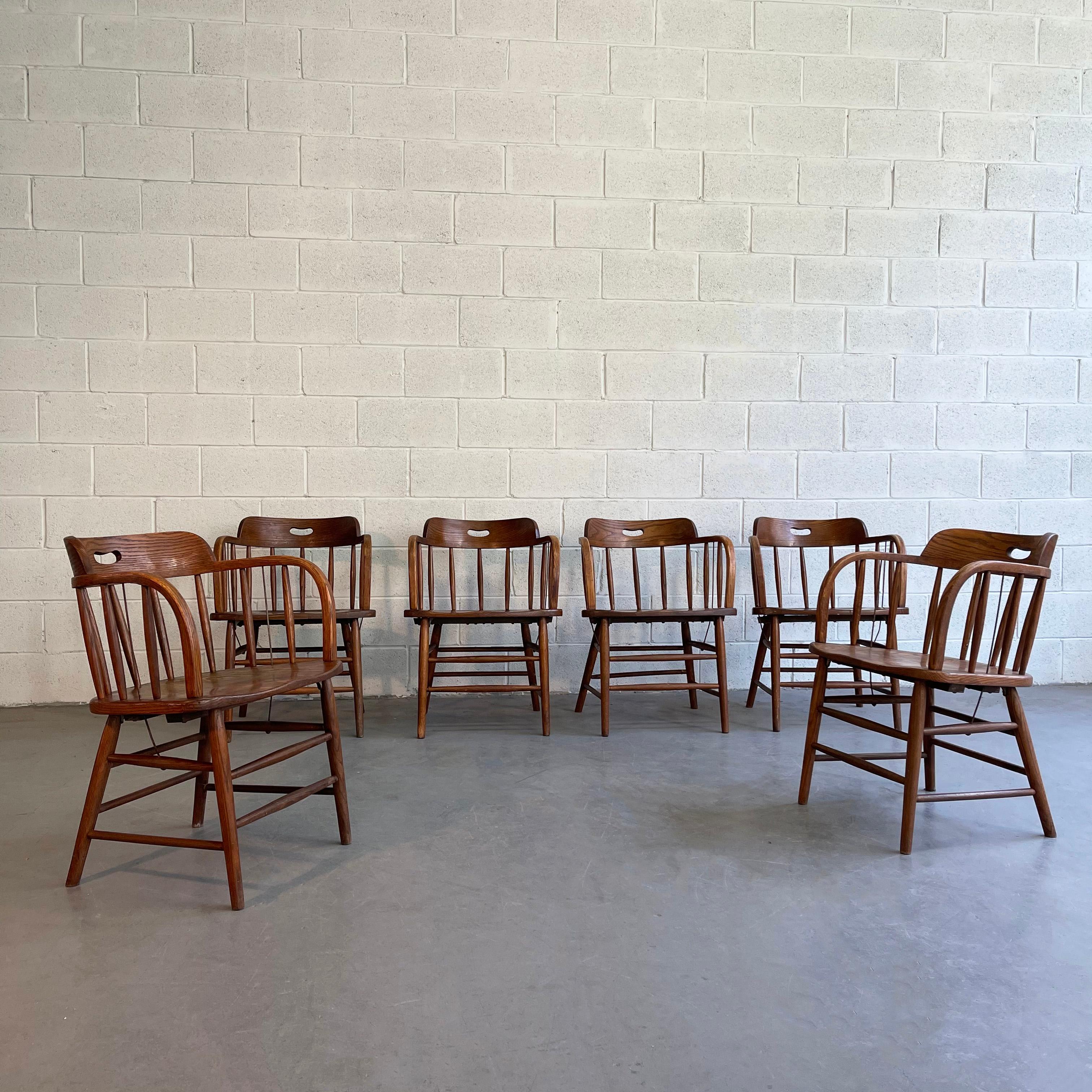 Set of six, Classic, 1940's, craftsman, oak, firehouse dining armchairs feature spindle backs and sides with metal reinforcement rods and wonderful oak grain throughout.
