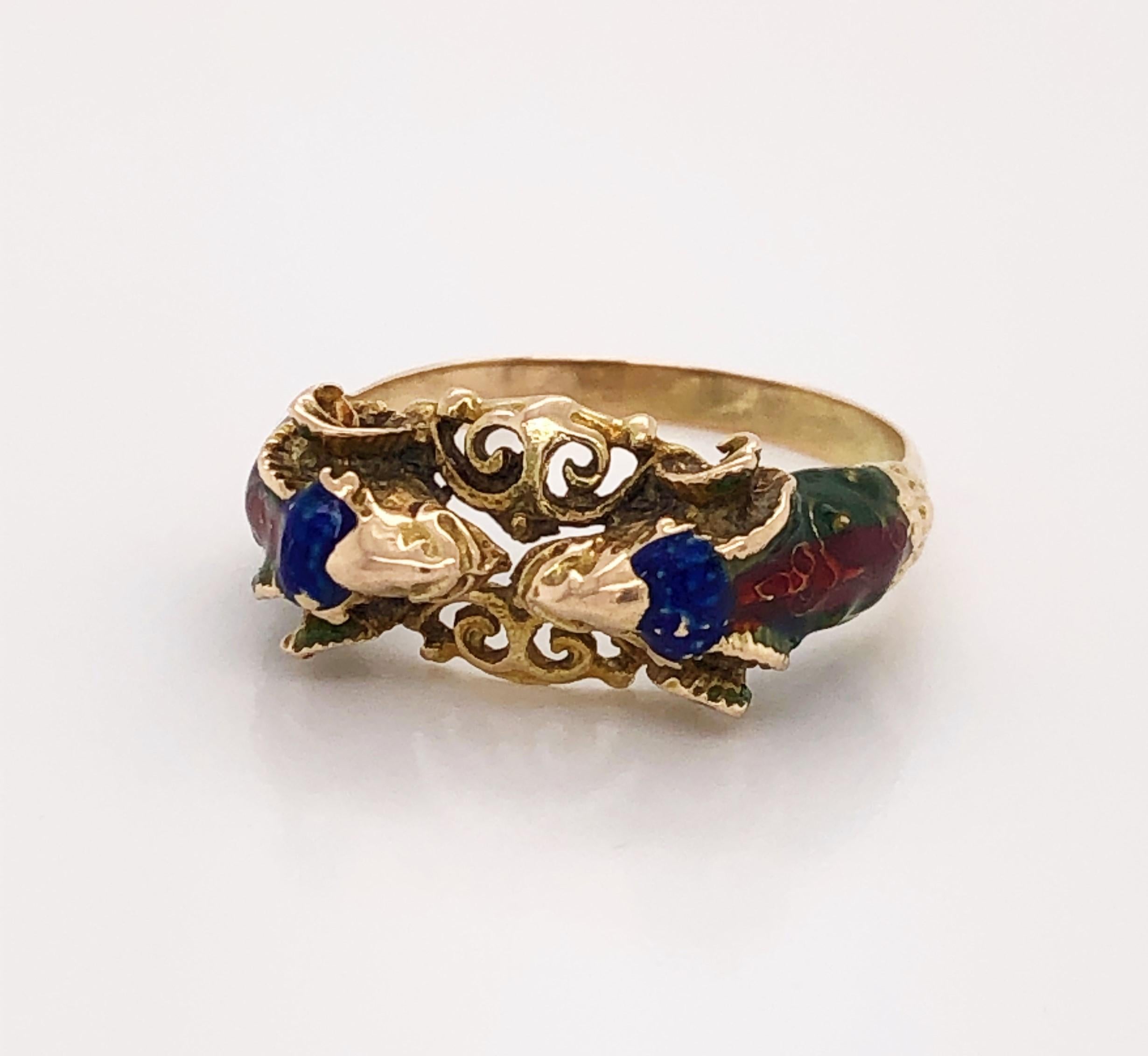 Two dueling rams create this interesting artisan ring in ten carat (10k) yellow gold. Bucking heads meet over center filigree and are hand painted with green, red and blue enamel accents. Unsigned. Band style in size 8-1/2 . in gift box.
