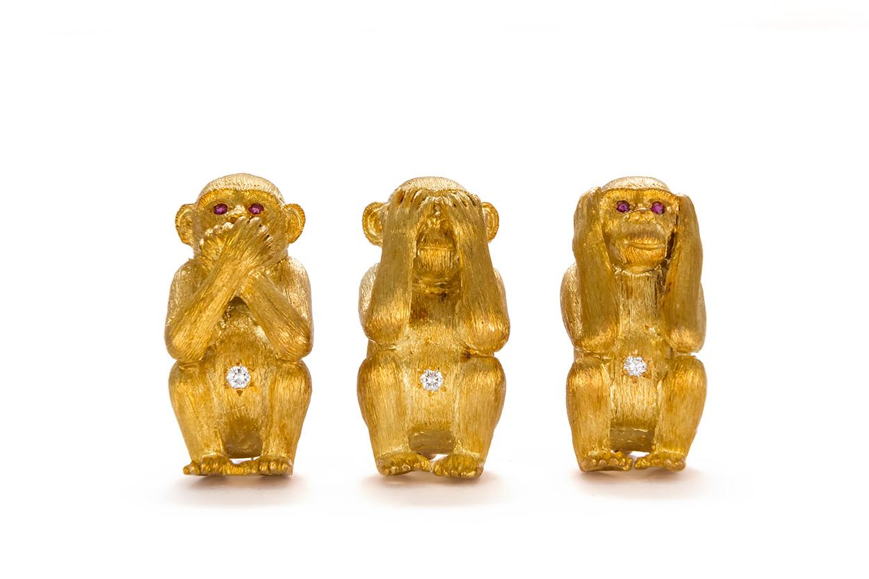 Craig Drake 18k Yellow Gold Diamond & Ruby Monkey Brooch Set. The brooch set features the speak no, see no, hear no evil motif and each of the monkeys has an estimated 0.05ct F/VS diamond set in the belly, tow of them feature ruby set eyes. The