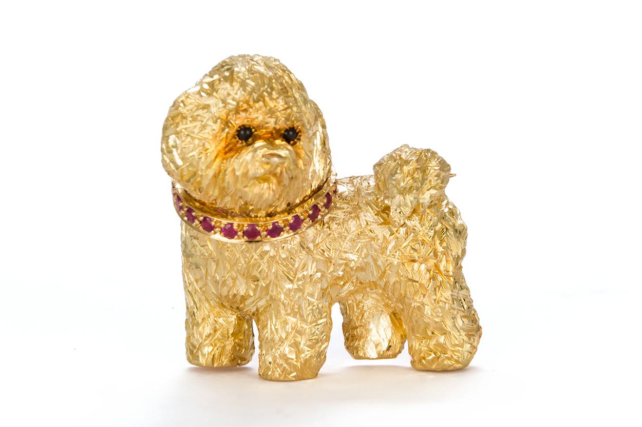 We are pleased to offer this Craig Drake 18k Yellow Gold & Ruby Dog Brooch. The brooch features a cute little dog fashioned from 18k Yellow Gold accented by an estimated 0.75ctw Round Brilliant Cut Rubies. The brooch measures approximately 1.25