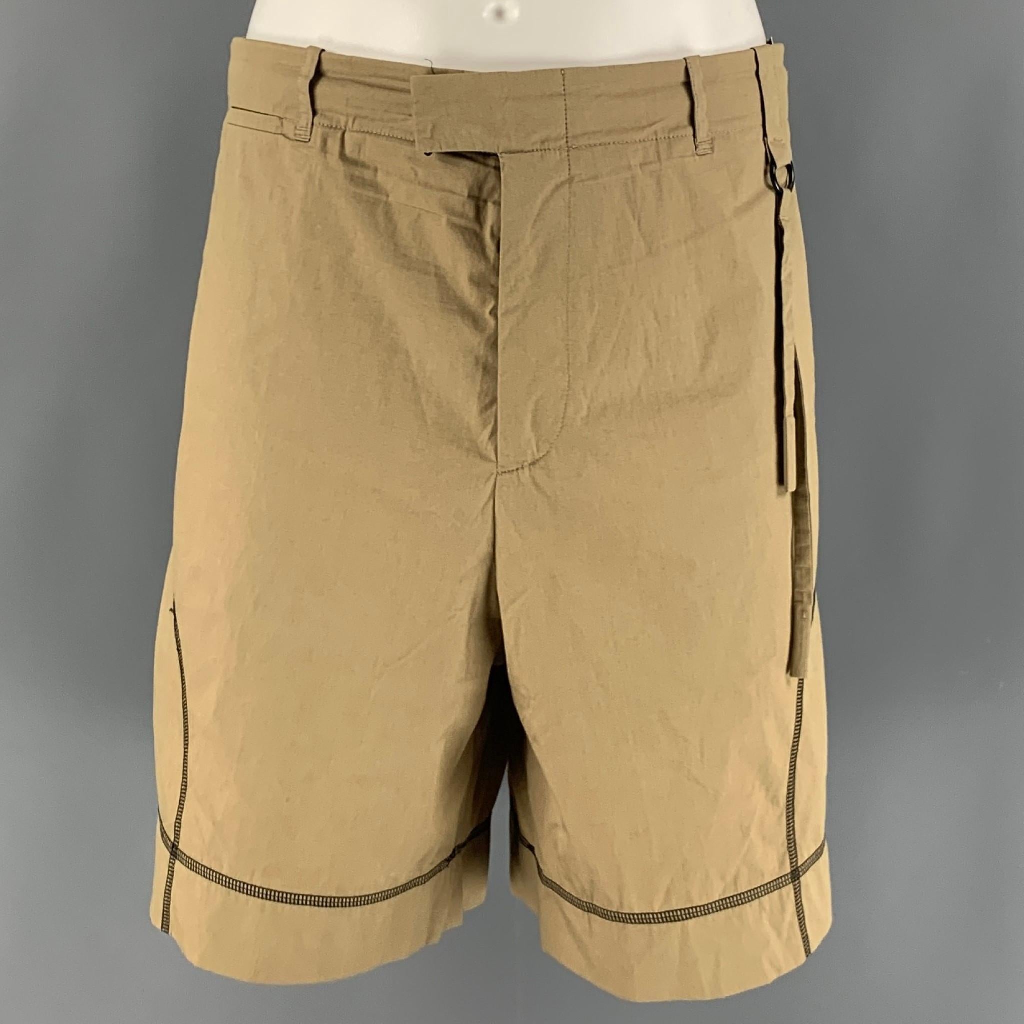 CRAIG GREEN shorts come in a khaki cotton microfiber material with a button tab waistband, contrast stitches, and zipper fly. Made in Italy.

Excellent Pre-Owned Condition.
Marked: L

Measurements:

Waist: 38 in.
Rise: 13 in.
Inseam: 7 in.  

SKU:
