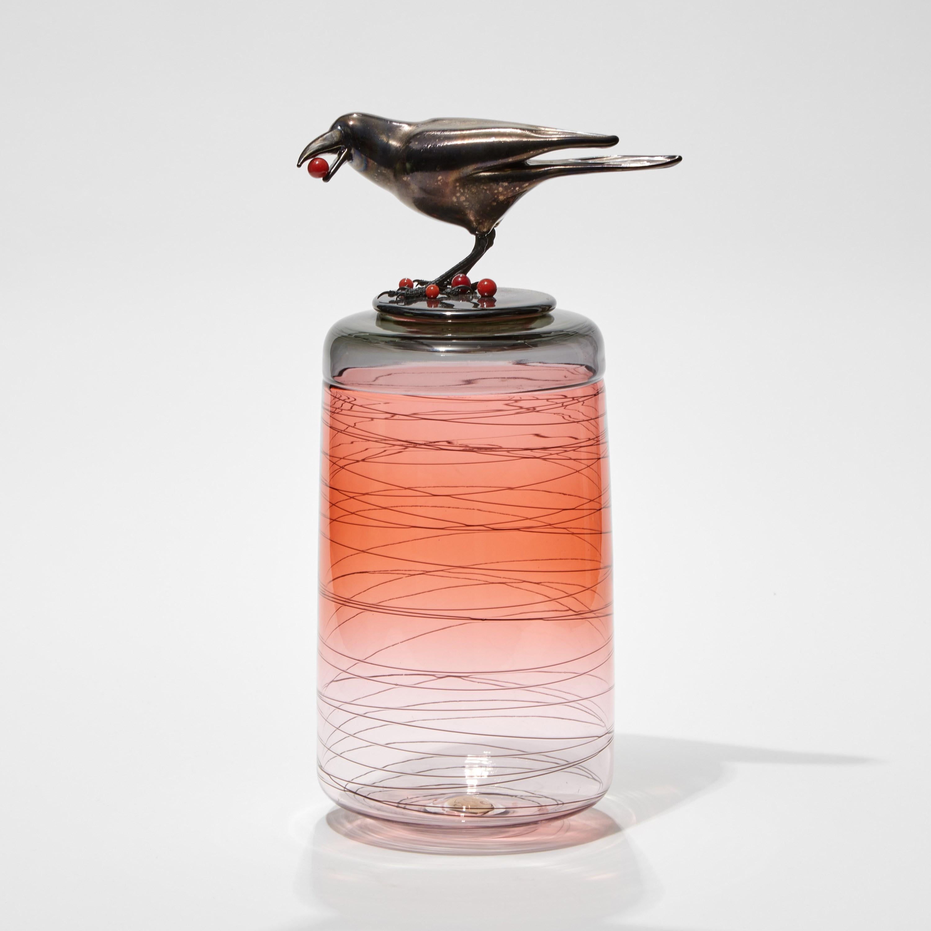 Cranberries II, is a hand-blown art glass vase in apricot / peach with a removable lid adorned with a hot sculpted black glass crow eating cranberries by the British artist Julie Johnson. The crow figurine can also be lifted off with the main body