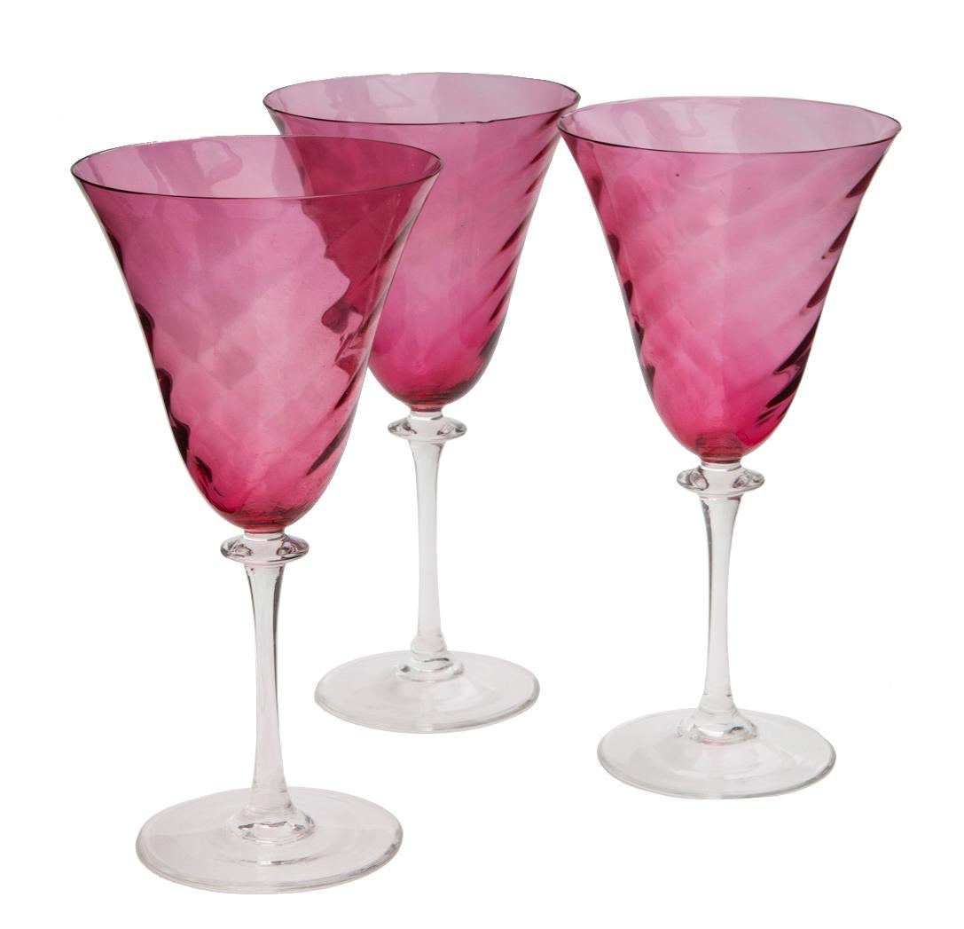 Impresionante juego de vasos altos de agua de arándanos rojos con un marcado dibujo de remolinos. Tallos transparentes.
