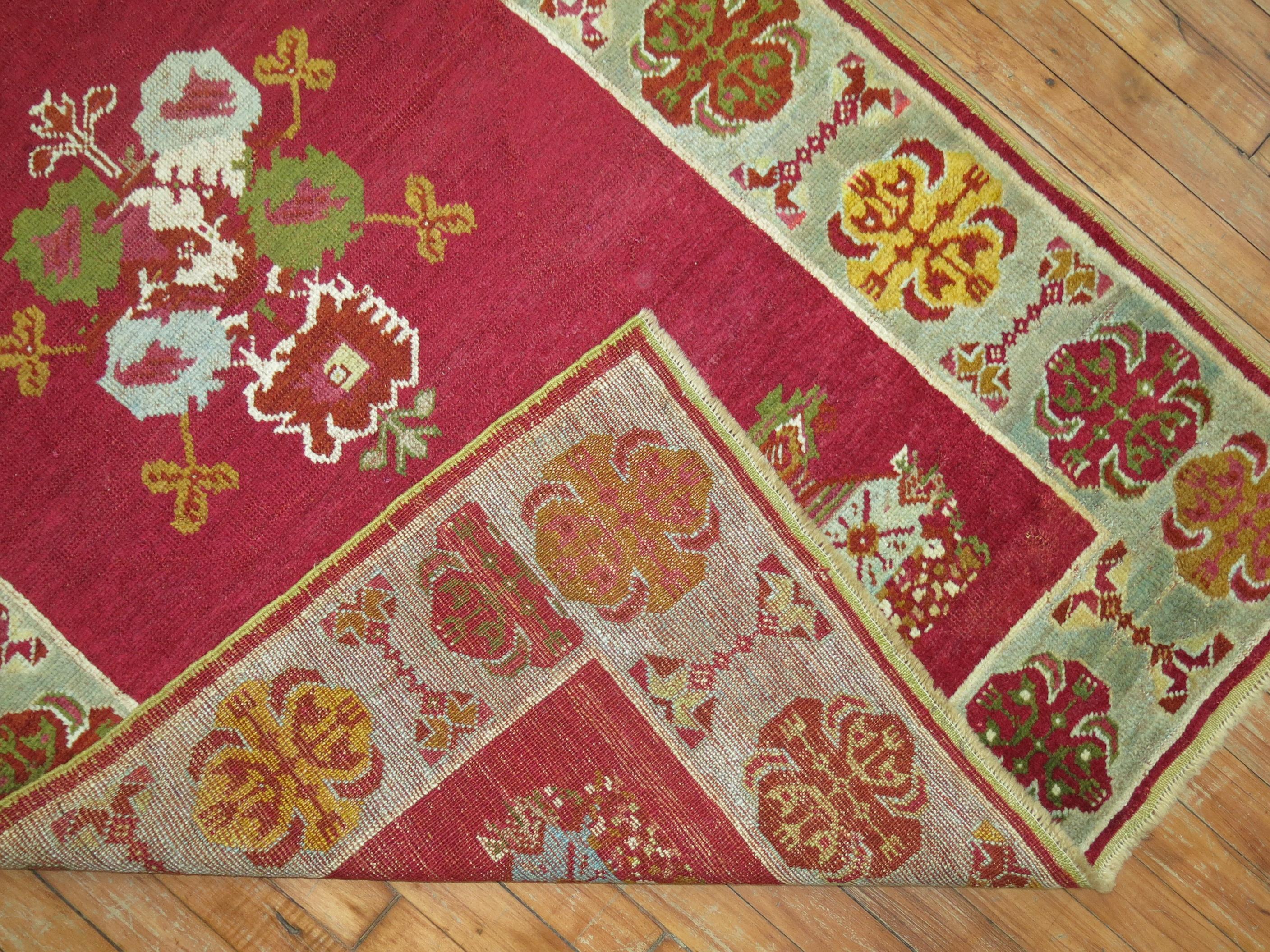 A charming Turkish rug with a raspberry field and light blue border. 

Measures: 3'4