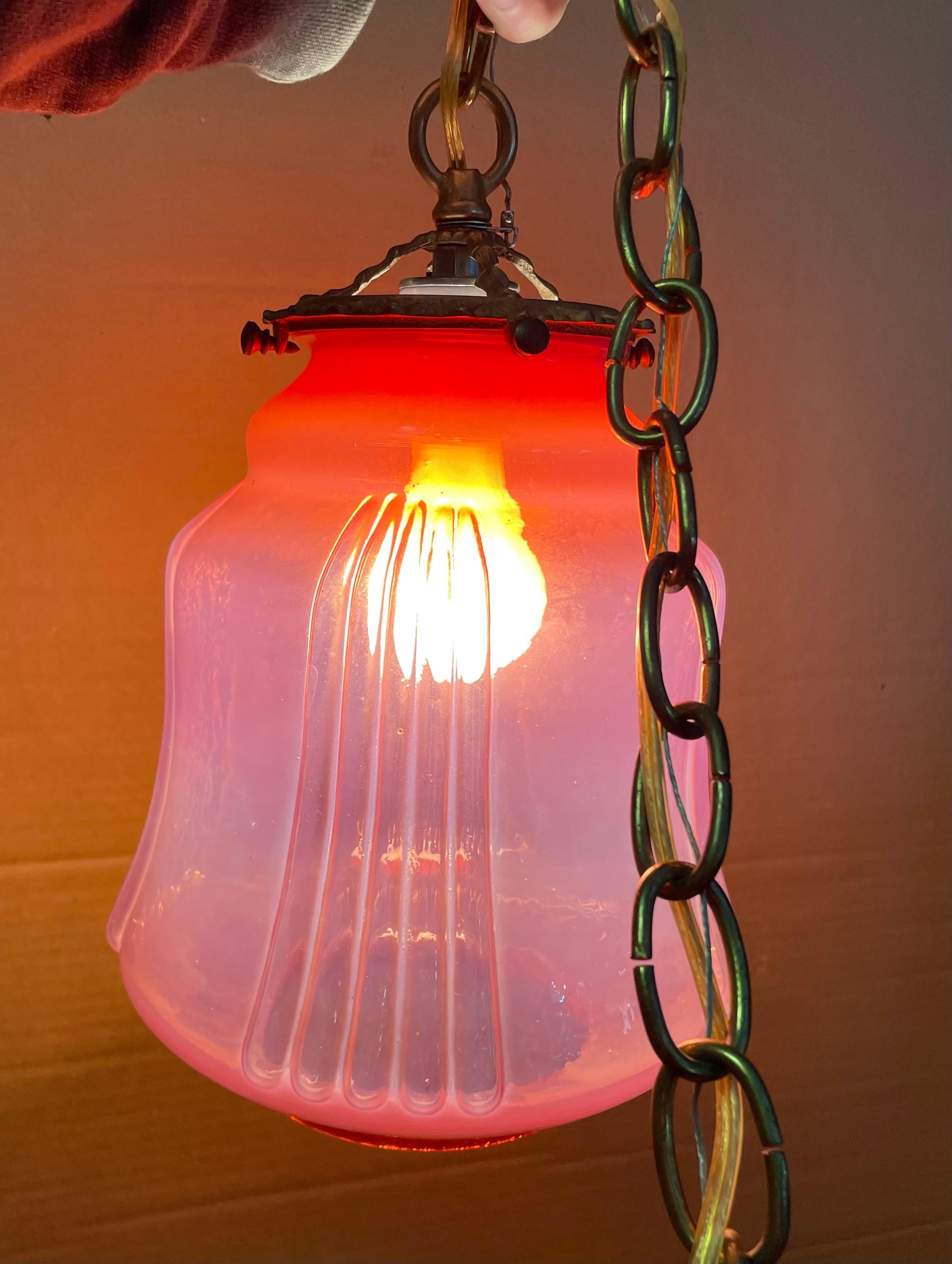 Una meravigliosa lampada a sospensione in vetro che emette un bellissimo bagliore quando è accesa e che riscalda qualsiasi ambiente con la sua atmosfera. Il vetro è di colore mirtillo rosso, ricoperto da un'opalescenza che attenua il rosso intenso.
