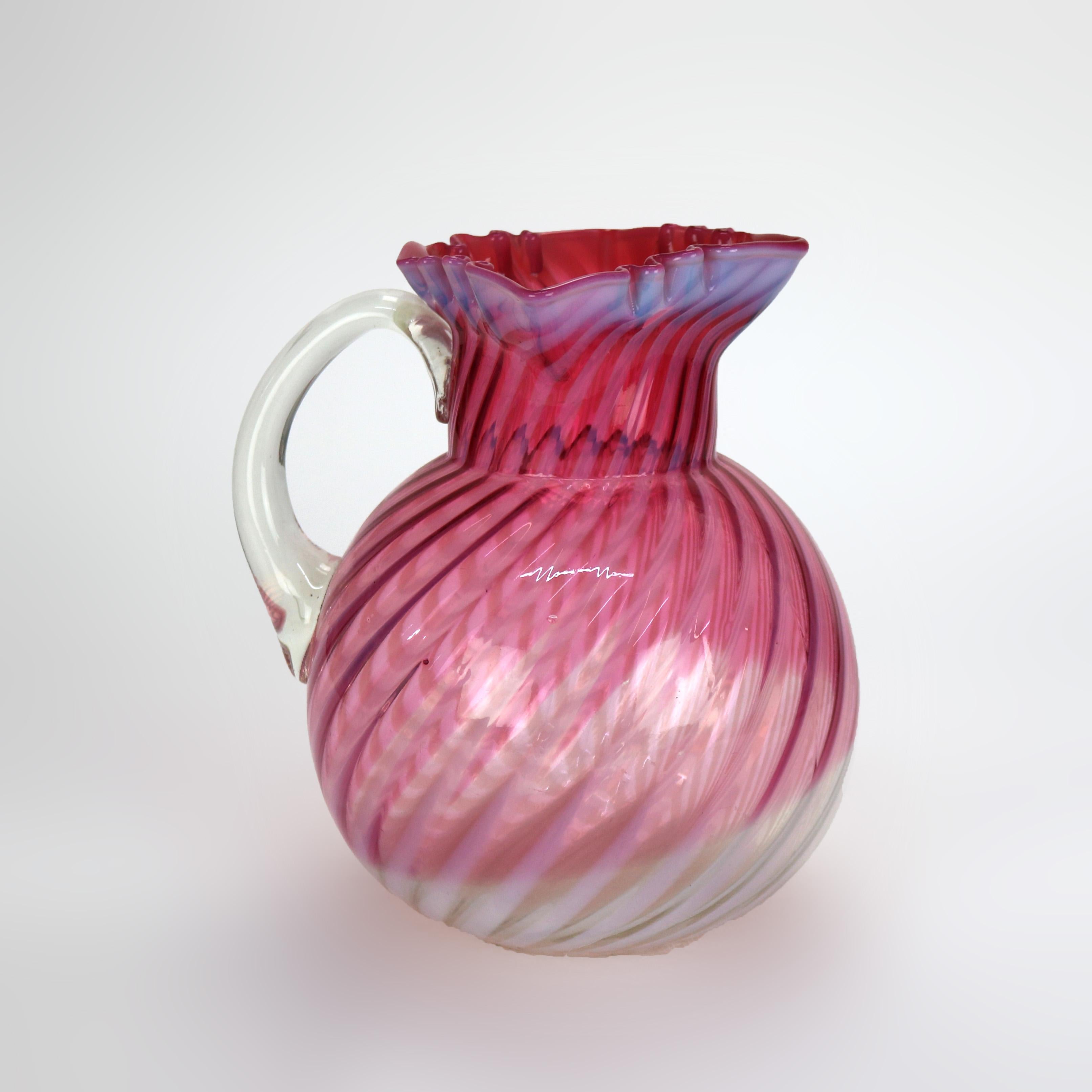 Pichet à jus de fruits en verre tourbillonné, canneberge et opalescent, avec rebord à volants, 20e siècle

Dimensions - 8 3/4
