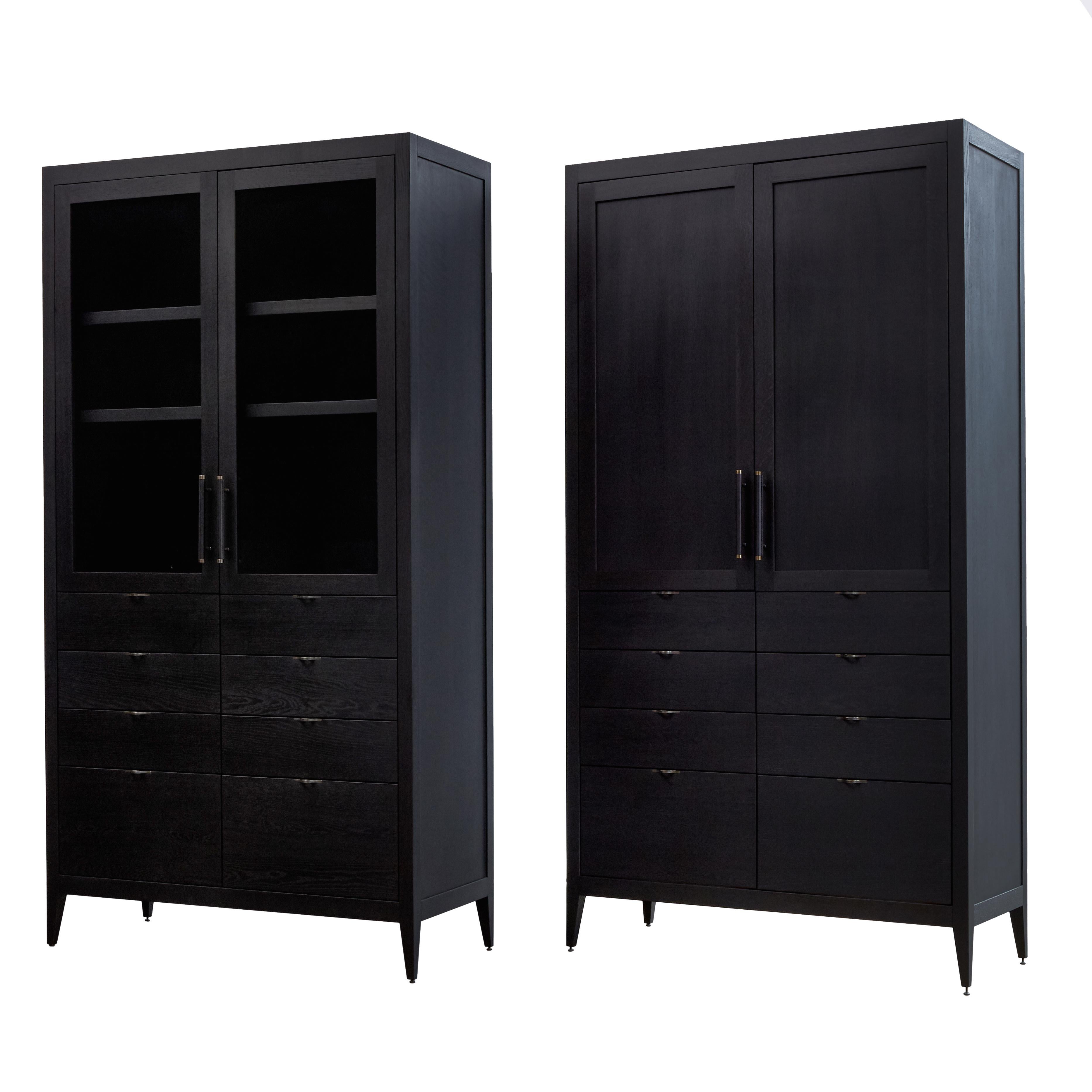 The Crane Cabinet is a premium modern cupboard comprised of two glass or solid panel doors with leather wrapped door pulls, two adjustable shelves, and eight soft-close maple dovetail drawers with brass finger pulls. Drawing on the clean minimalism