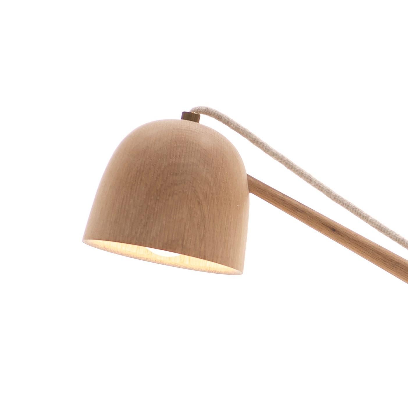 The Crane Floor lamp displays delicate components that celebrate the best qualities of wood craftsmanship. The grain texture stems from the careful and deliberate process of turned wood fabrication. The lamp has a seamless angular design, cotton