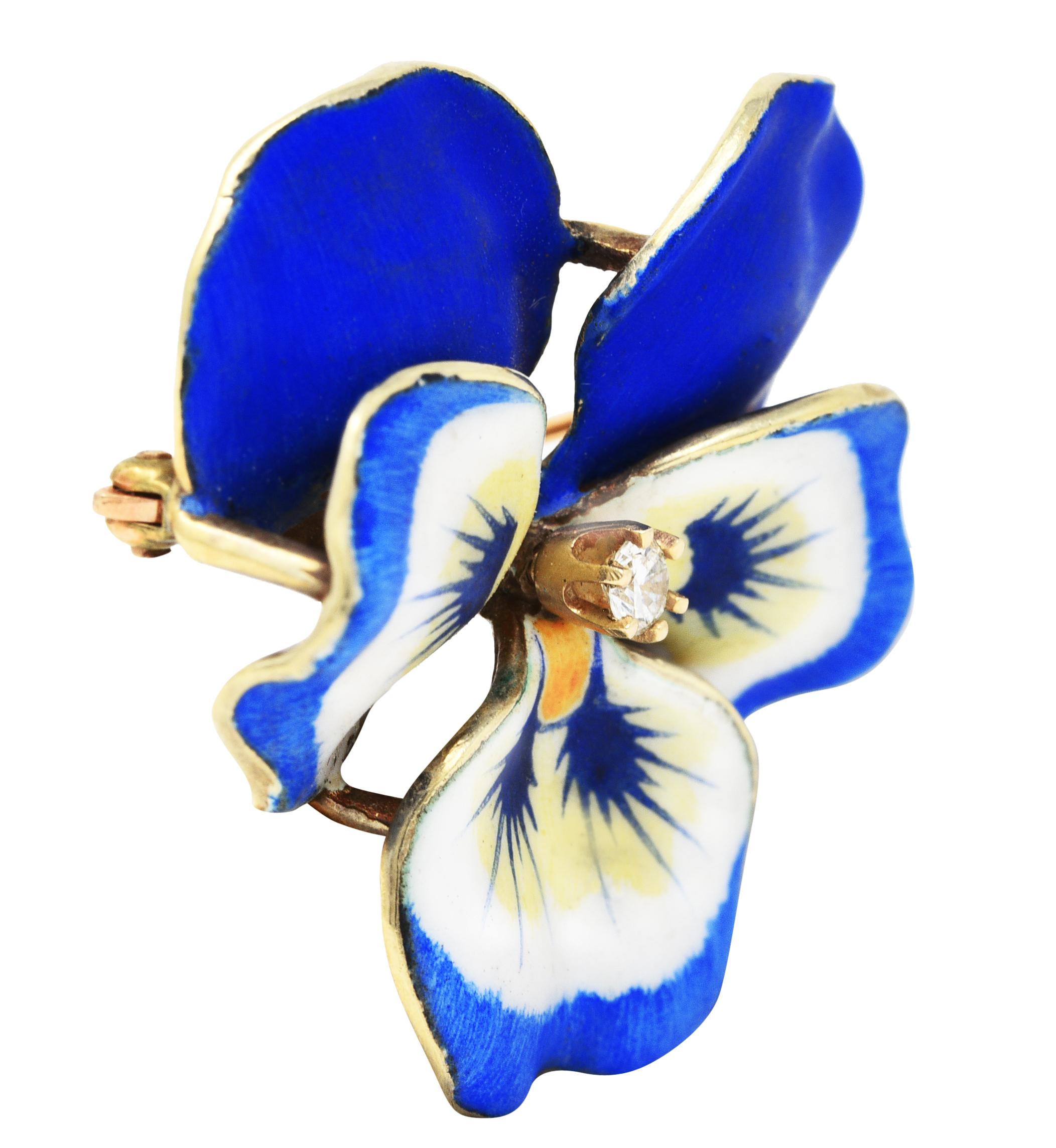 Pendant brooch is designed as a pansy flower with delicately painted matte enamel petals. Opaque blue, white, and yellow - exhibiting minimal loss. Accented by a prong set transitional cut diamond. Weighing approximately 0.10 carat total - eye clean