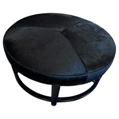 Crate & Barrel Pouf rotondo in pelle con rotelle cromate, stile modernista