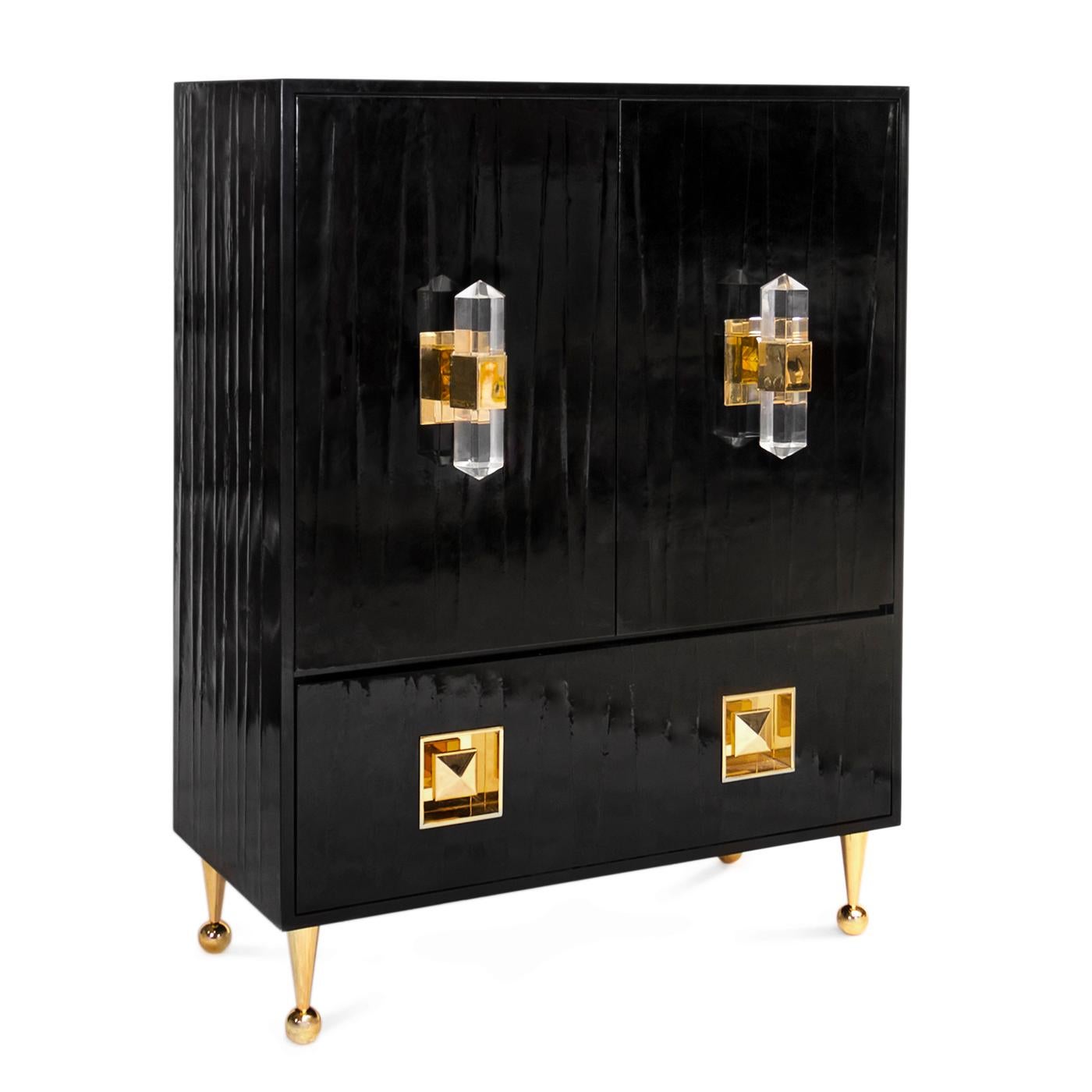 Megawatt modern. Hollywood Glam and Studio 54 hedonism collide in our Crawford cabinet. Glossy black lacquer featuring a subtle ripple texture is perched on our signature ball and cone polished brass legs. The pièce de résistance, faceted acrylic