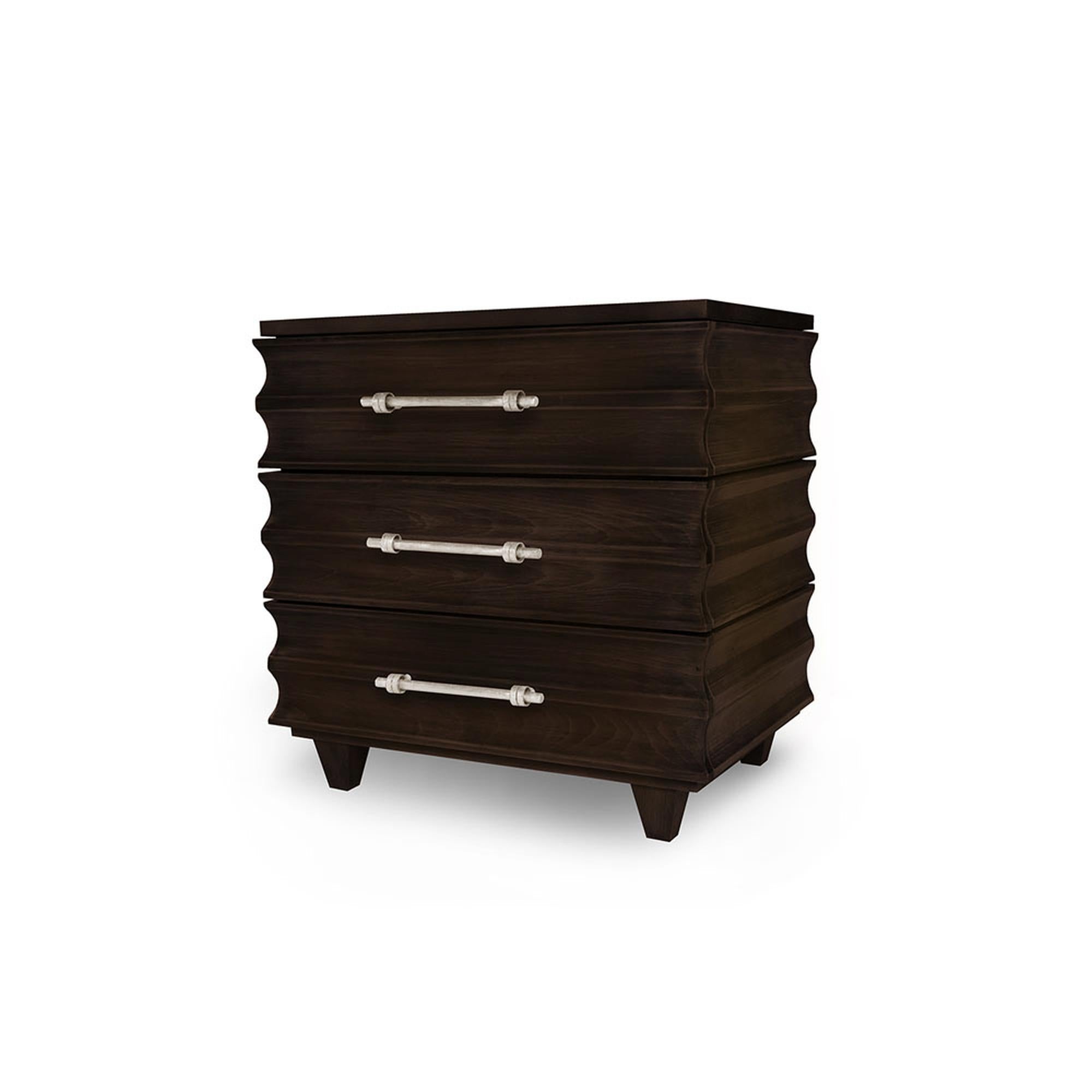 Design, detail, and style are synonymous with the carved to perfection Crawford nightstand. Made of solid wood, the drawers are scalloped and feature three softclose drawers, hand-gilded antique silver metal pulls, and a mirrored top. There’s