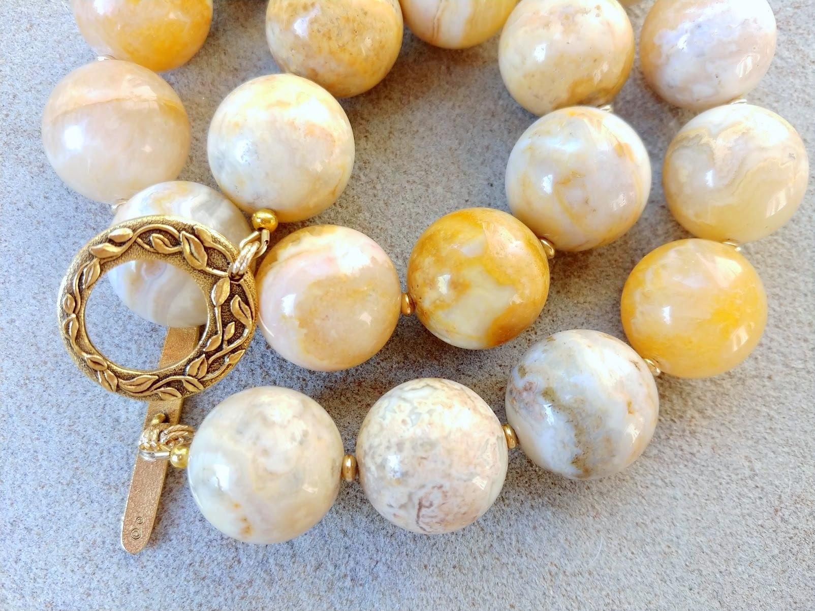 The length of the necklace is 18.5 inches (47 cm).
The size of the smooth round beads is 20 mm.

Yellow or Crazy Lace Agate (also known as Mexican Agate) is a banded chalcedony (microcrystalline quartz) infused with iron and aluminum. It is often
