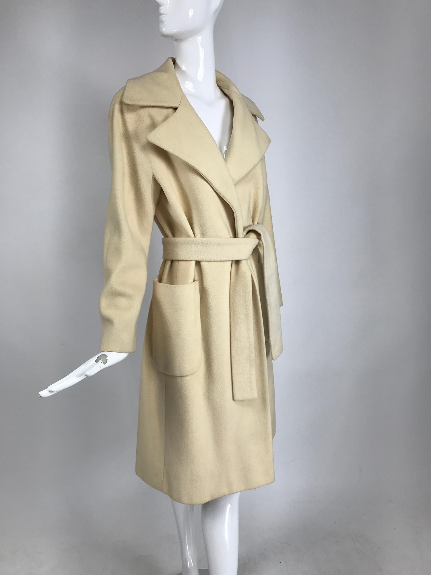 Cream 100% cashmere wrap coat with patch pockets from the 1970s. A beautiful coat with some high end sewing details, the coat back and sleeve backs are cut from one piece of fabric, the sleeves are seamed along the outside center, the sleeve fronts