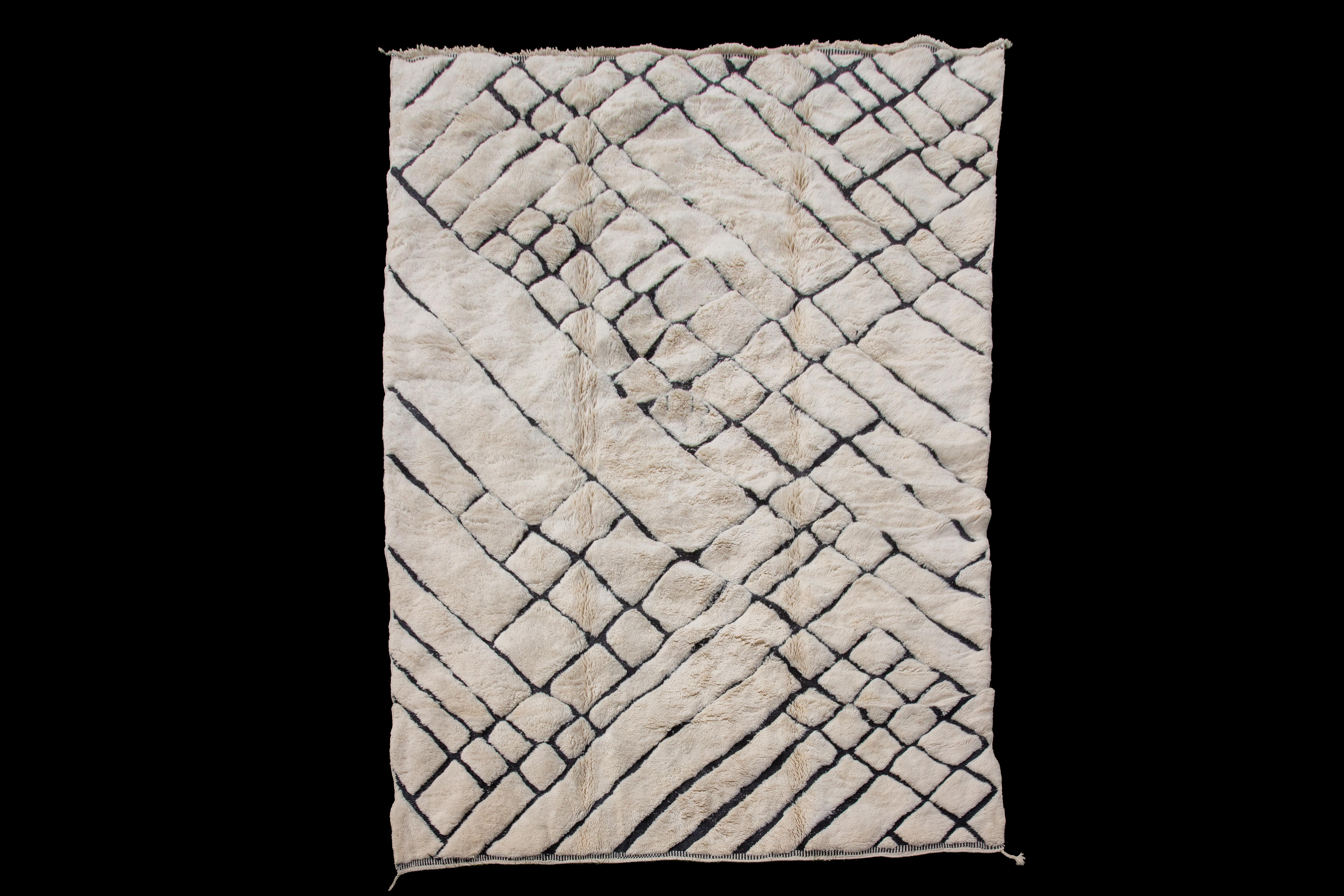Abstrakter marokkanischer Teppich in Creme, eine moderne Neuinterpretation des traditionellen Designs. Mit seinem cremefarbenen Hintergrund und den abstrakten schwarzen Linien verleiht dieser Teppich jedem Raum einen modernen Touch. Mit den Maßen